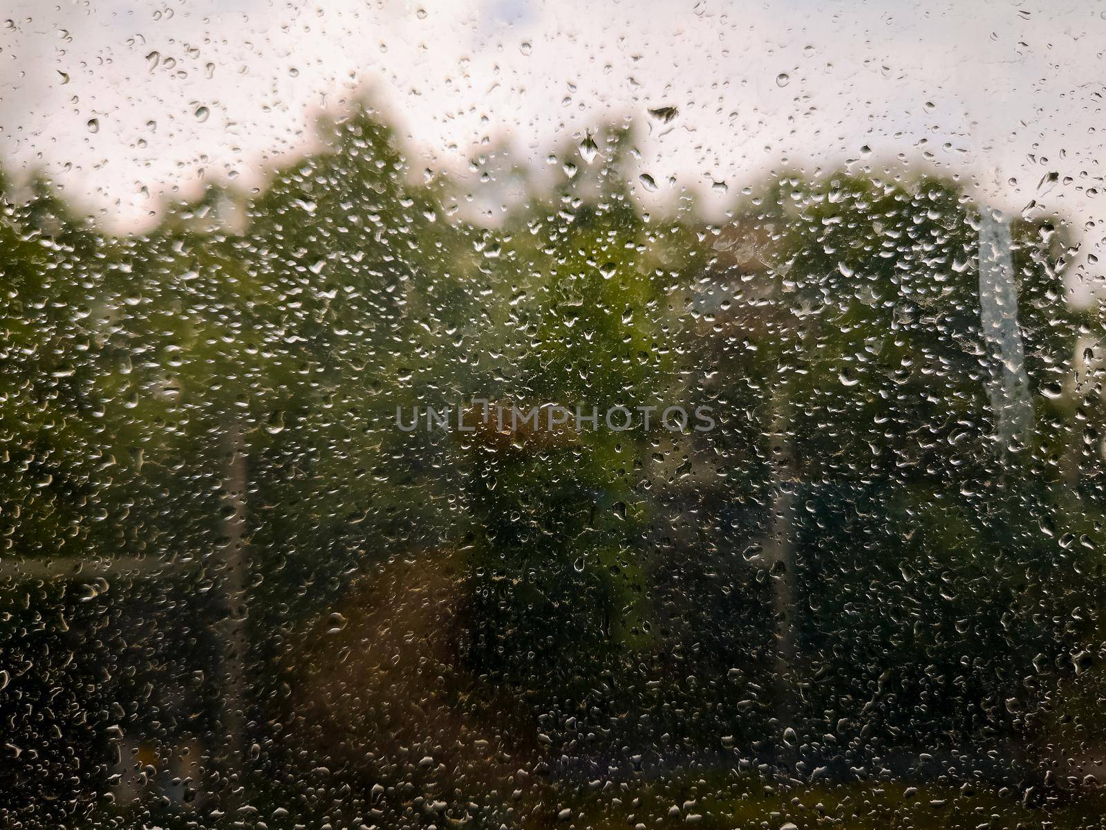 Dirty window full of water drops at rainy weather