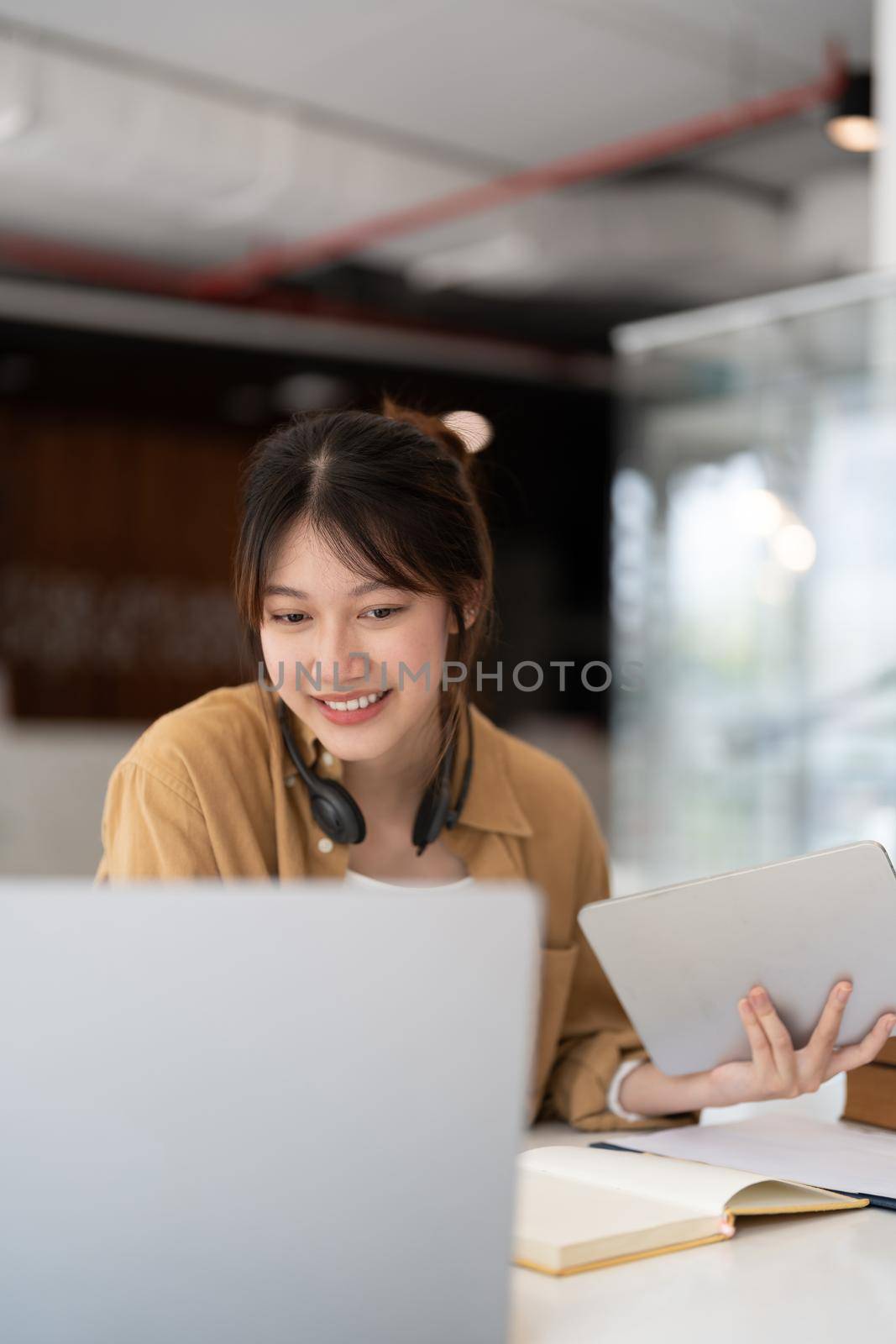 Portrait of young asian woman using laptop working or learning on laptop indoors- educational course or training, seminar, education online concept