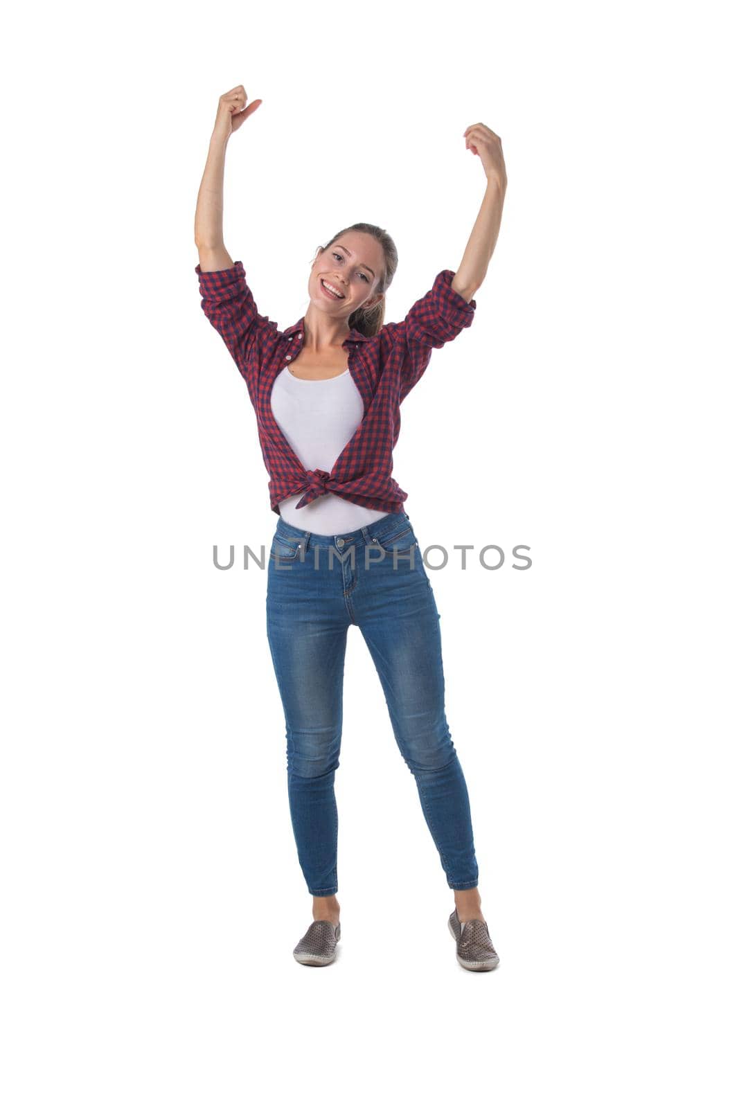Full-length shot of beautiful girl in shirt and jeans holding arms outstretched up isolated on white background