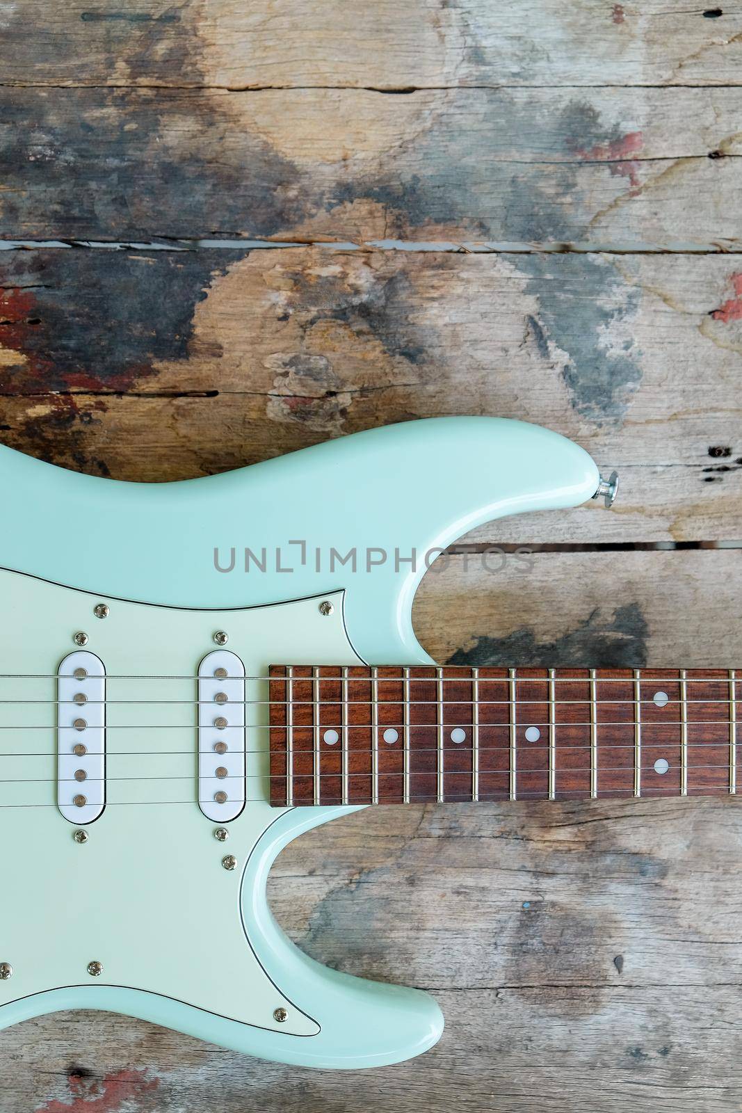 Detail of Mint Green Electric Guitar on a wood background.