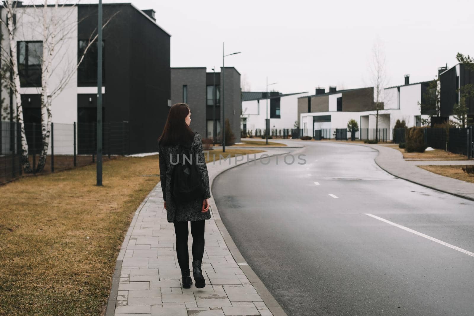 young woman walks through the street in spring