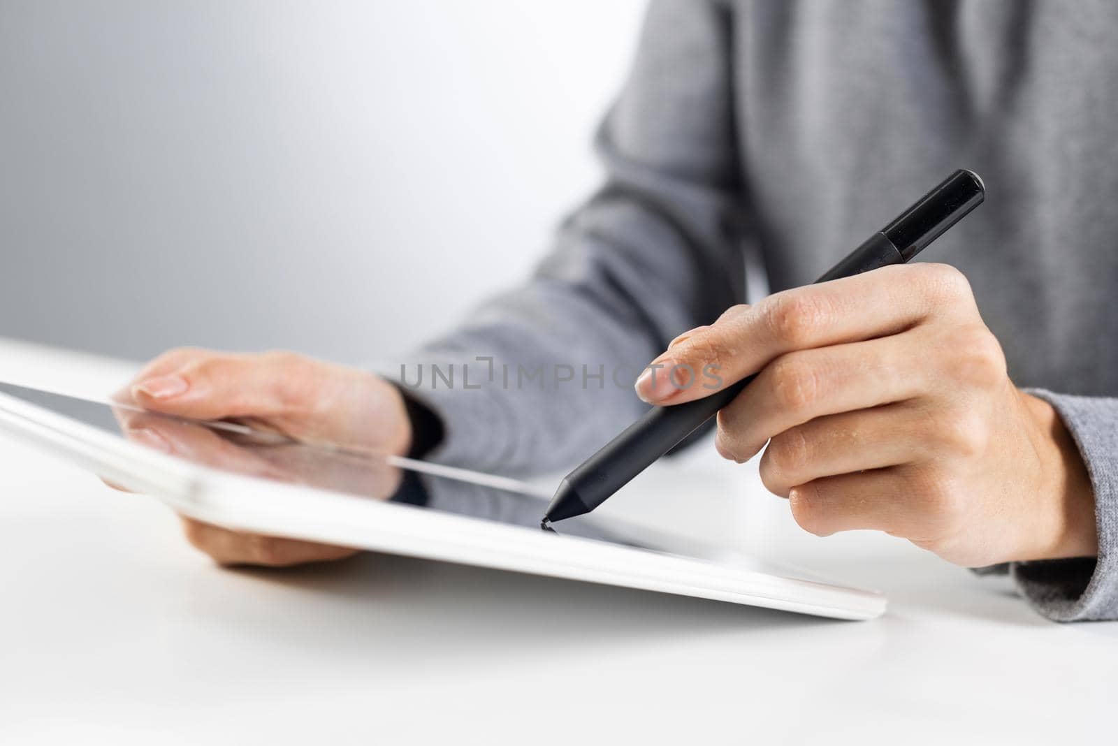 Businesswoman using tablet computer for news read. Close-up of female hands holding tablet device at office desk. Online business statistics and analytics. Modern workplace in innovate company