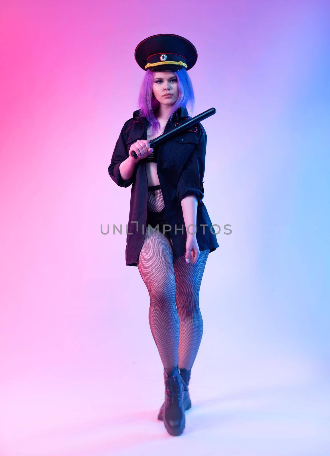 Sexy girl in police uniform posing in underwear with a police rubber baton in neon light by Rotozey