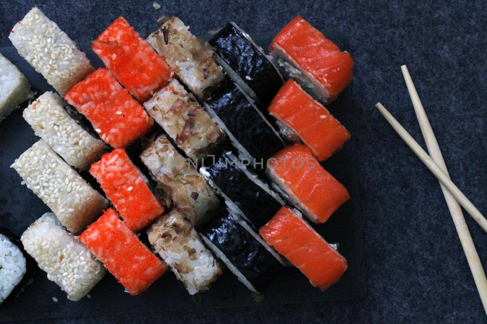 A set of rolls and sushi sticks on a dark background. Japanese cuisine. Background. Healthy eating. High quality photo