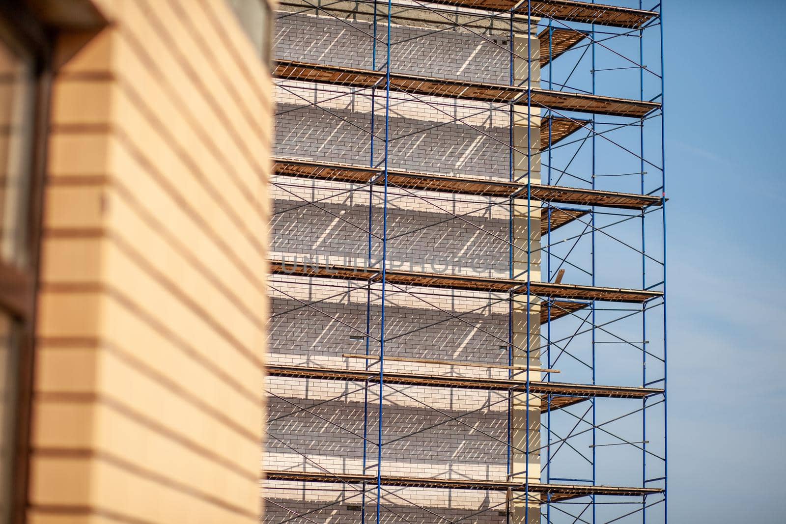 Scaffolding, metal mobile scaffold aginst blue sky background.  by AnatoliiFoto