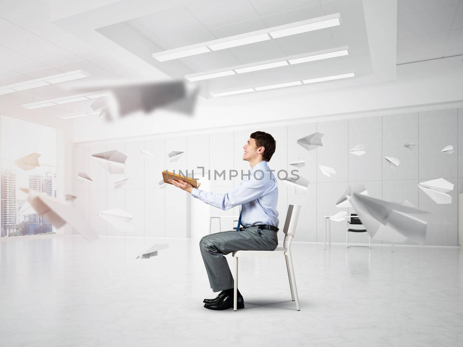 young businessman with book on office chair