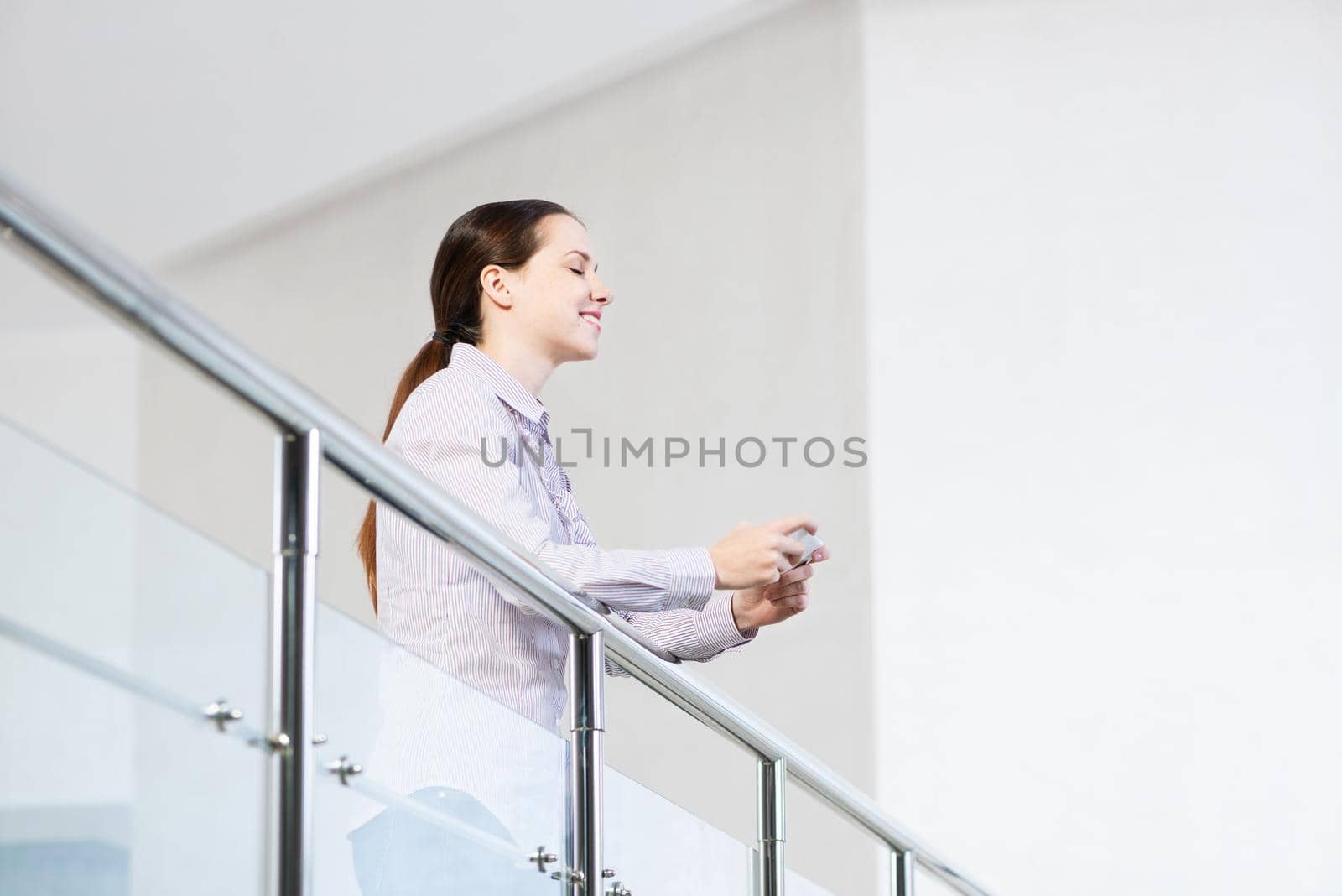 A young woman holds a cell phone. typing in a smartphone.