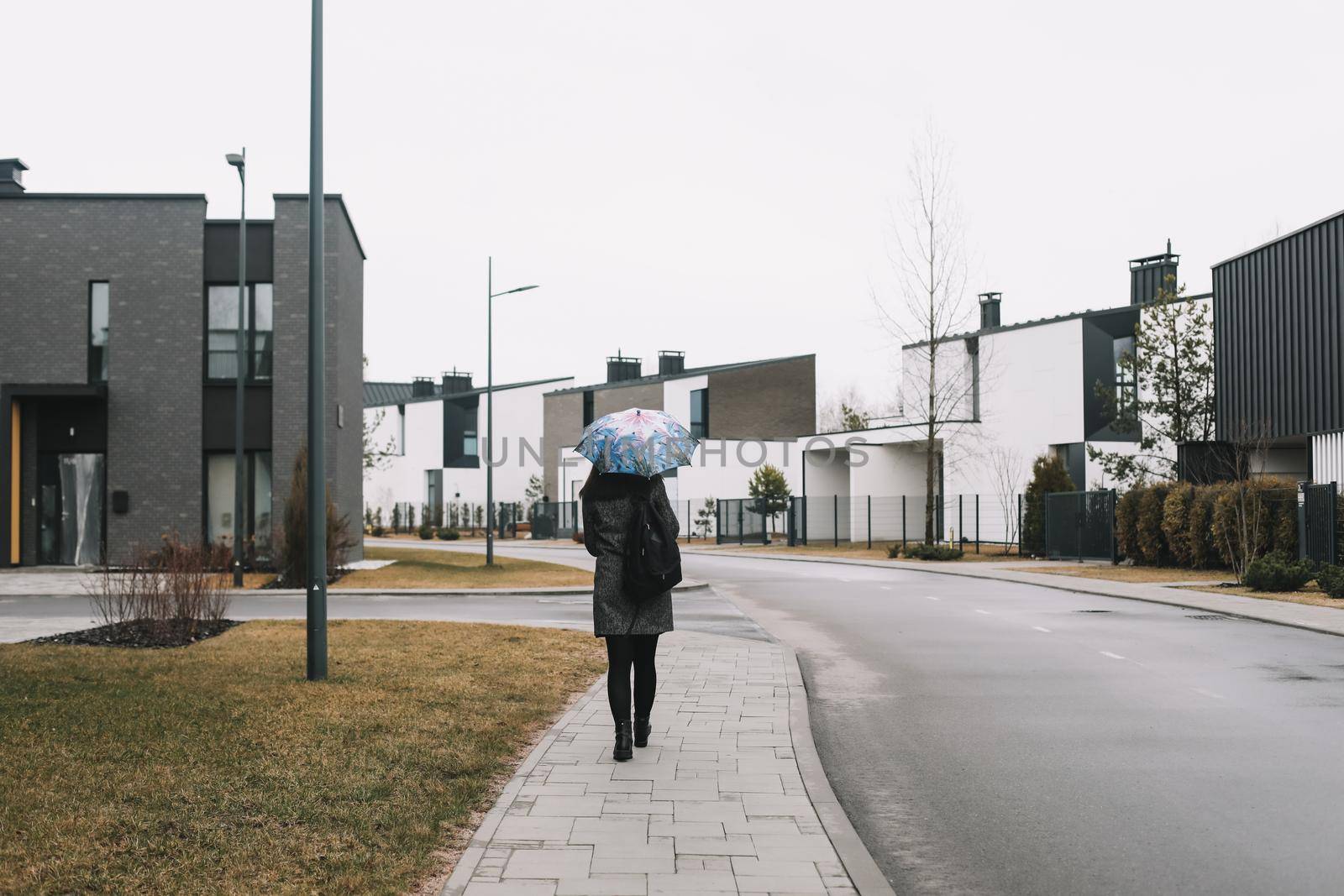 Portrait of a young woman with umbrella outdoors in the street.