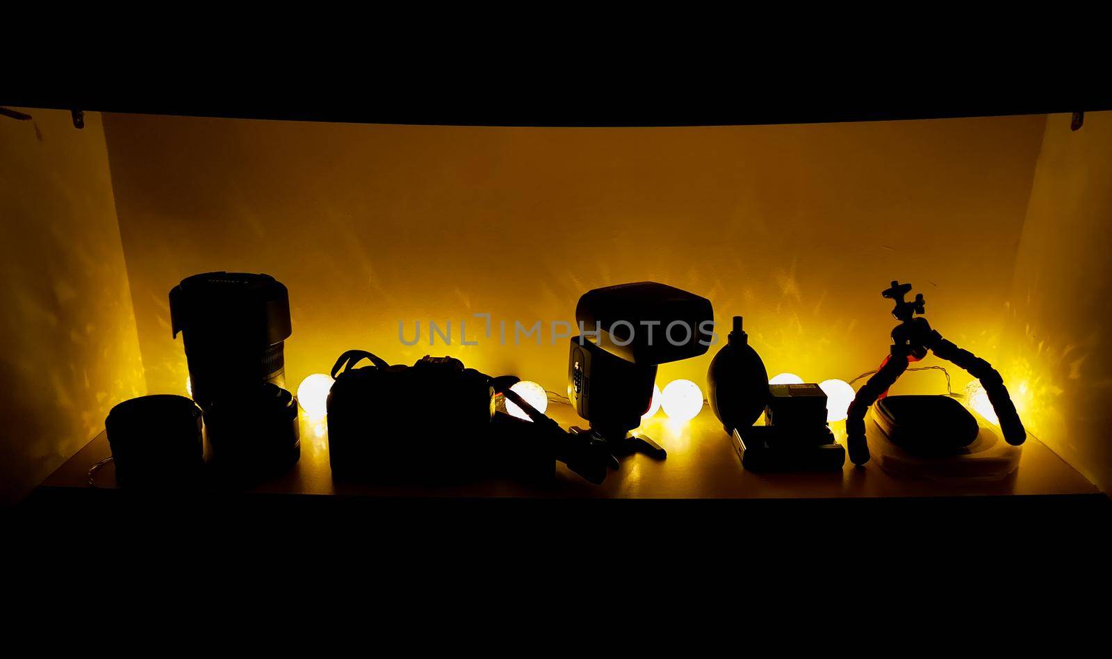 Photography equipment standing on shelf with light balls behind