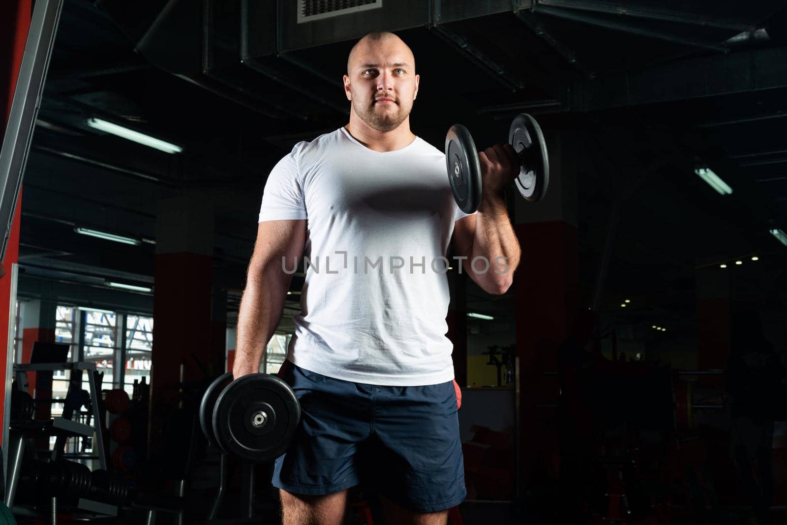 Male bodybuilder engaged with dumbbells in the gym. Healthy lifestyle