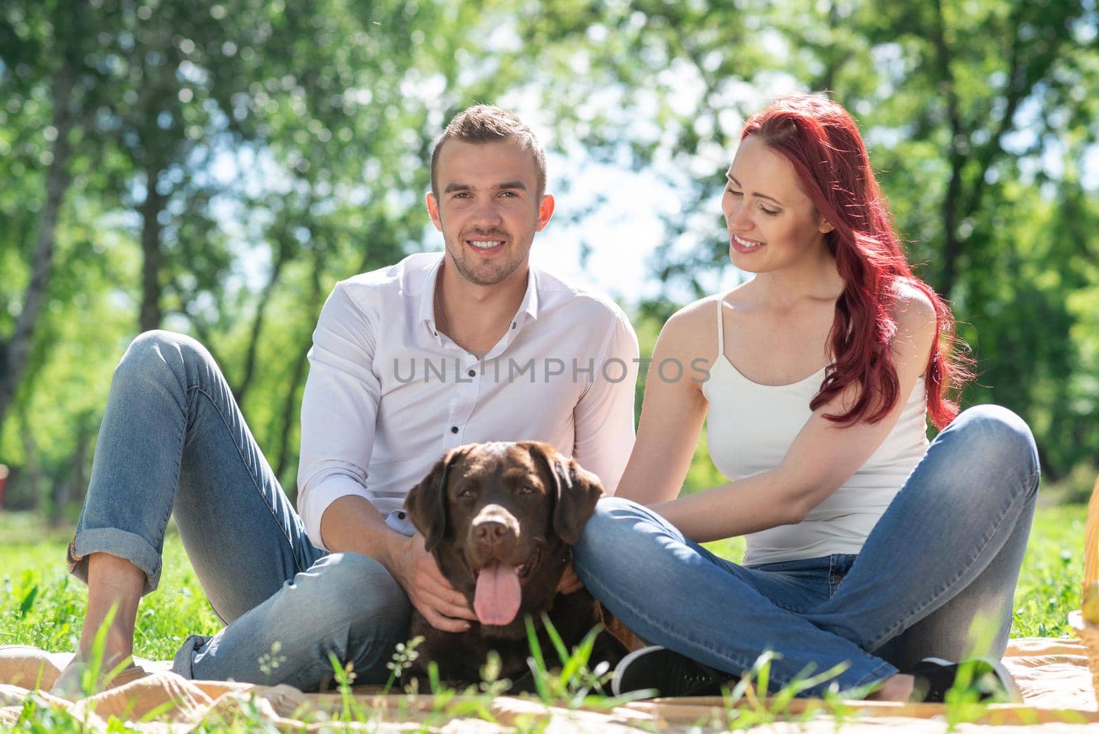 A couple and their dog in the park. Spending time with friends