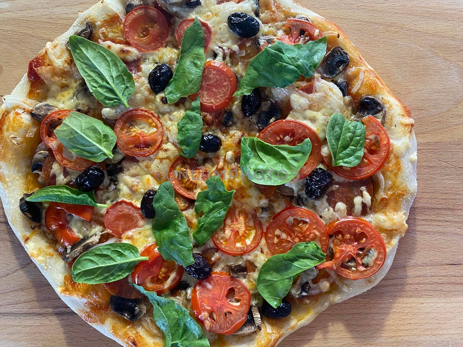 Delicious freshly baked pizza, just out of the oven on a wooden board by Proxima13