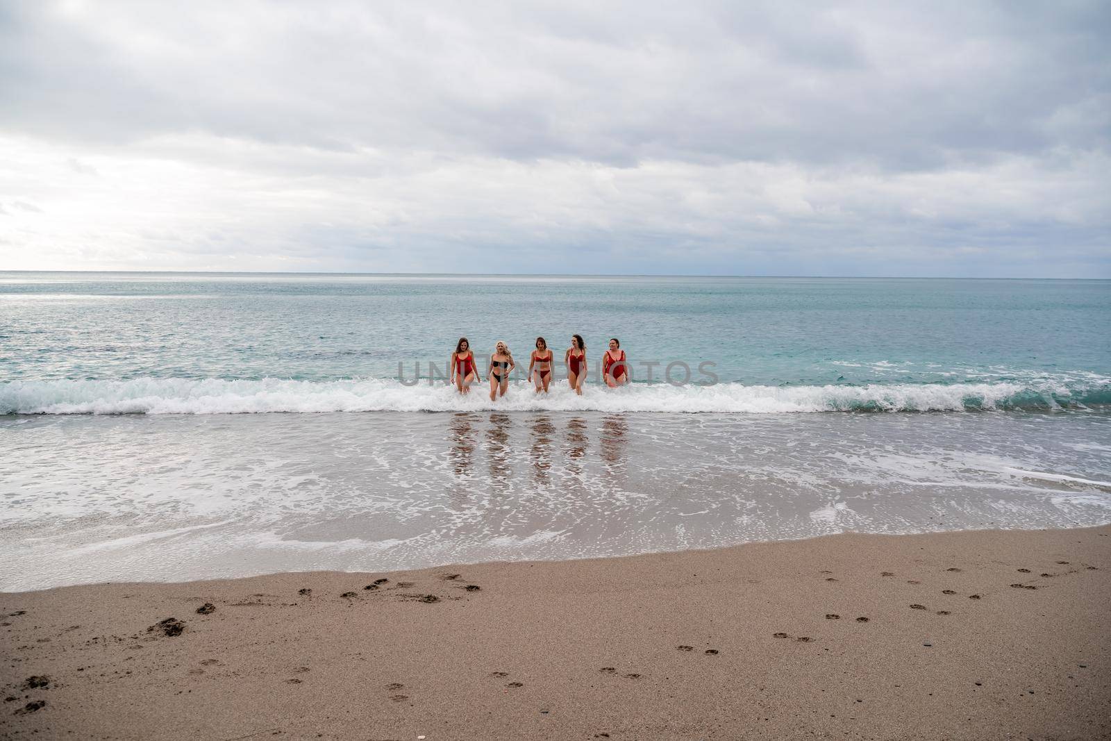 Big happy family or group of five friends is having fun against sunset beach. Beach holidays concept