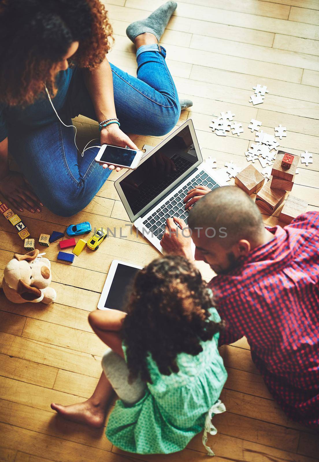 Finding fun things to do online. Shot of a family of three using modern technology at home. by YuriArcurs