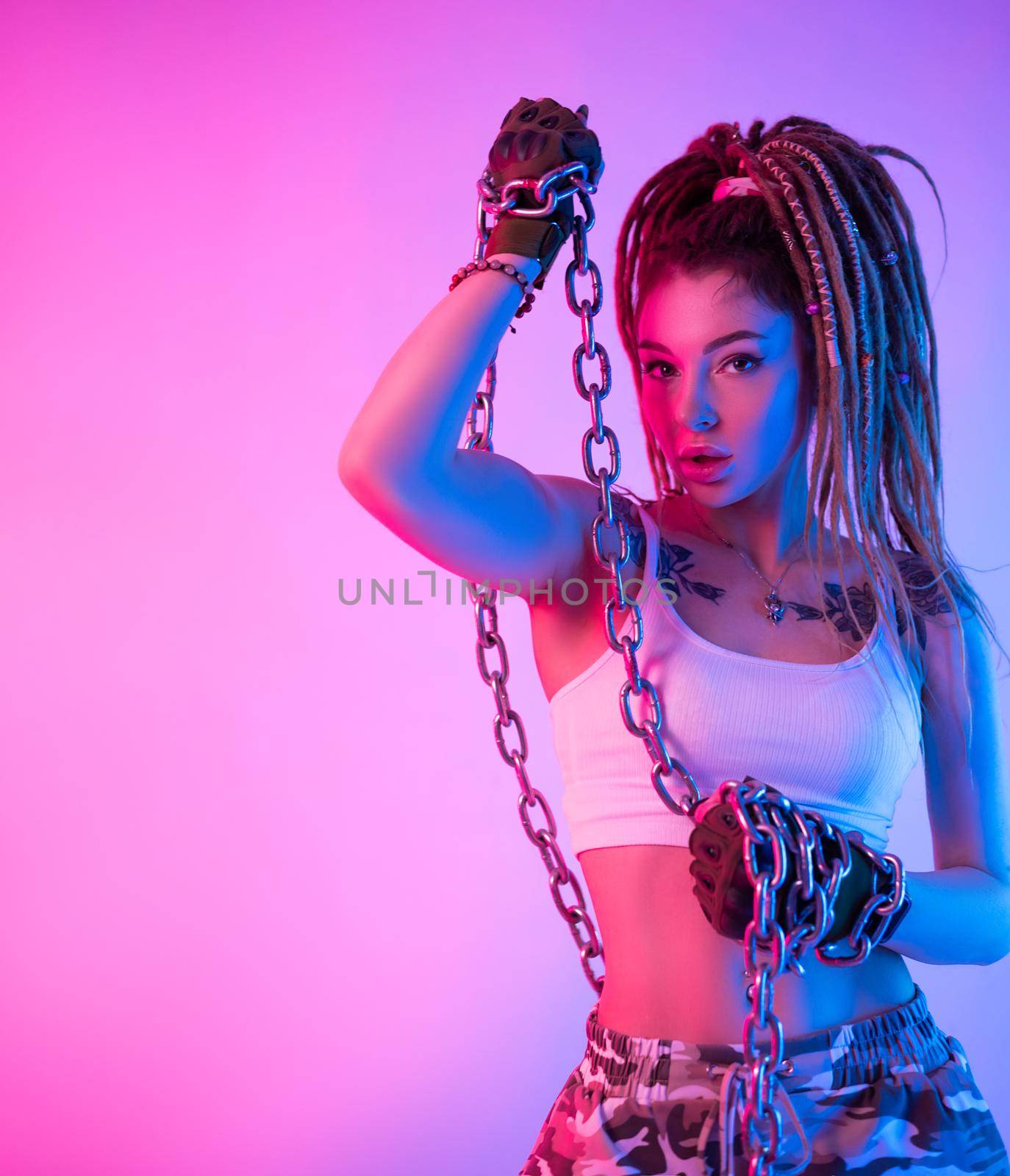 a fighter girl with chains on her hands with beautiful dreadlocks on her head in neon light by Rotozey