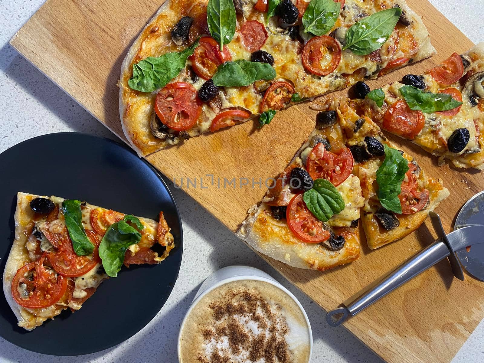 Delicious freshly baked pizza, just out of the oven on a wooden board.