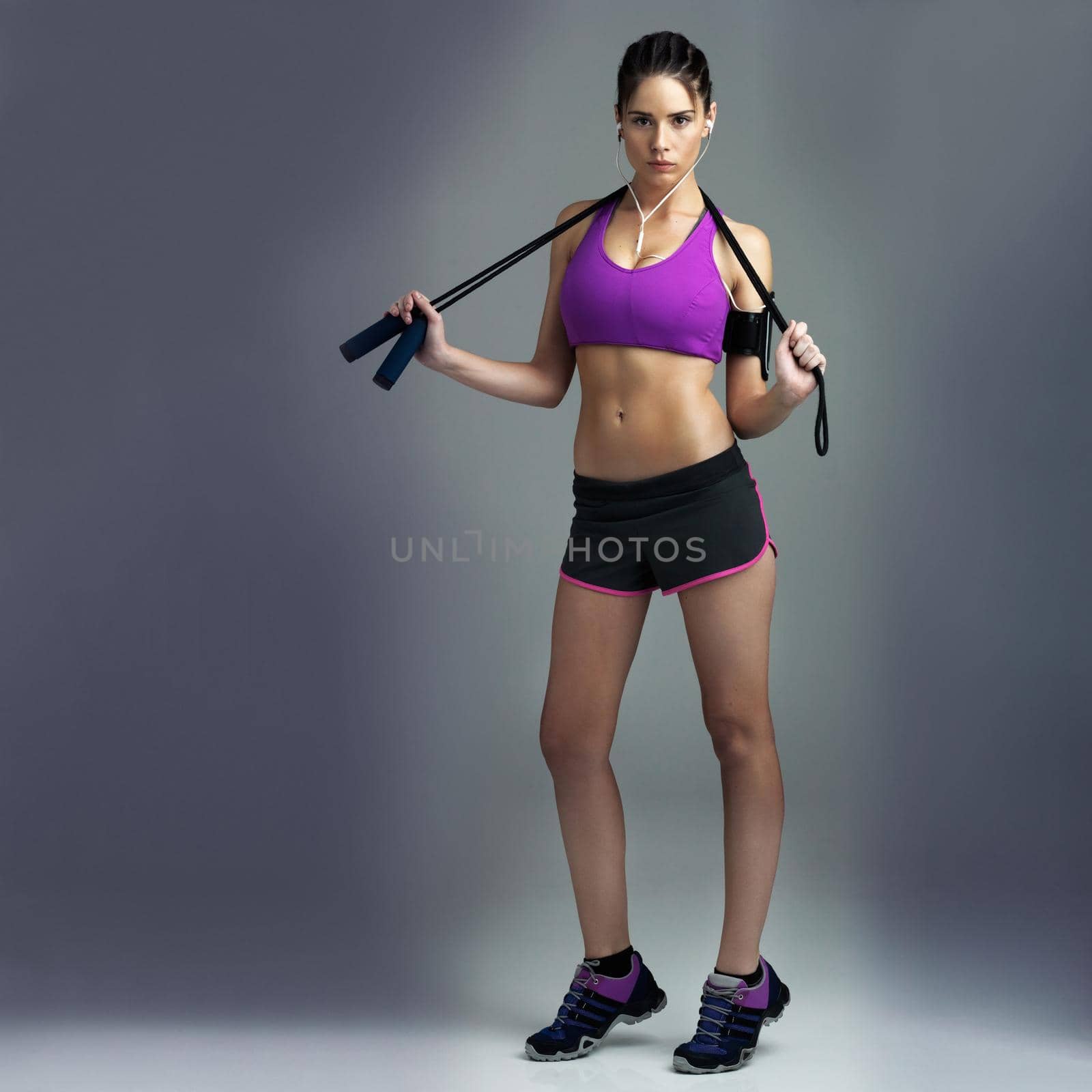 Determined to get fit. Studio shot of a sporty young woman against a gray background. by YuriArcurs