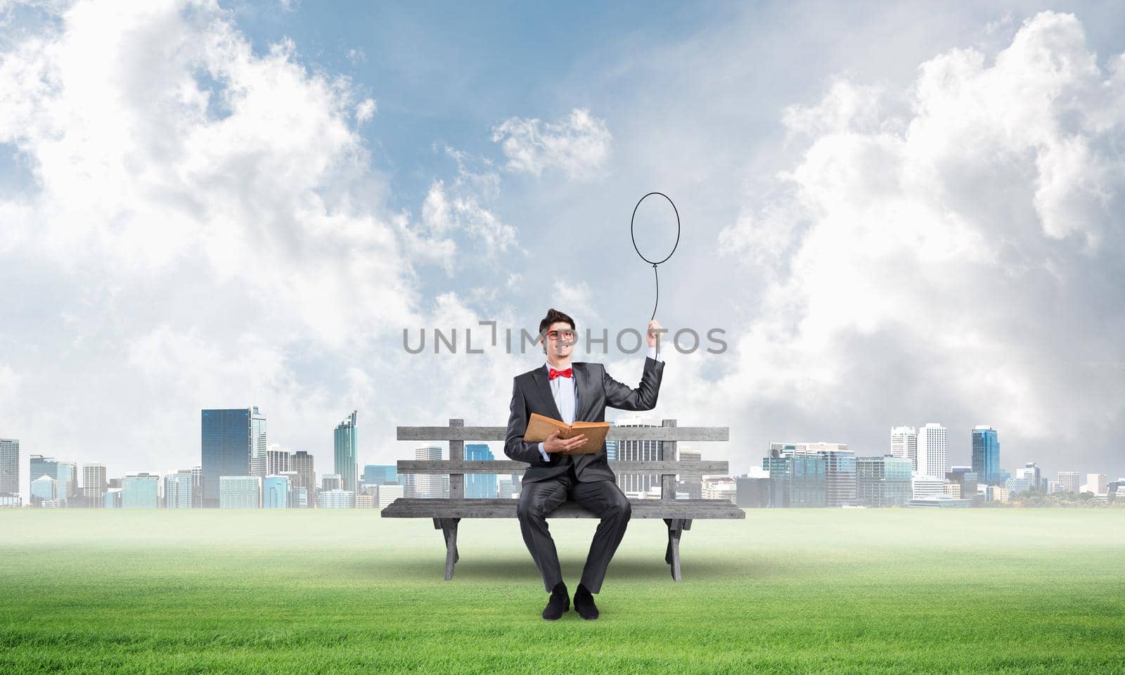 Young student sits on a wooden bench with a book