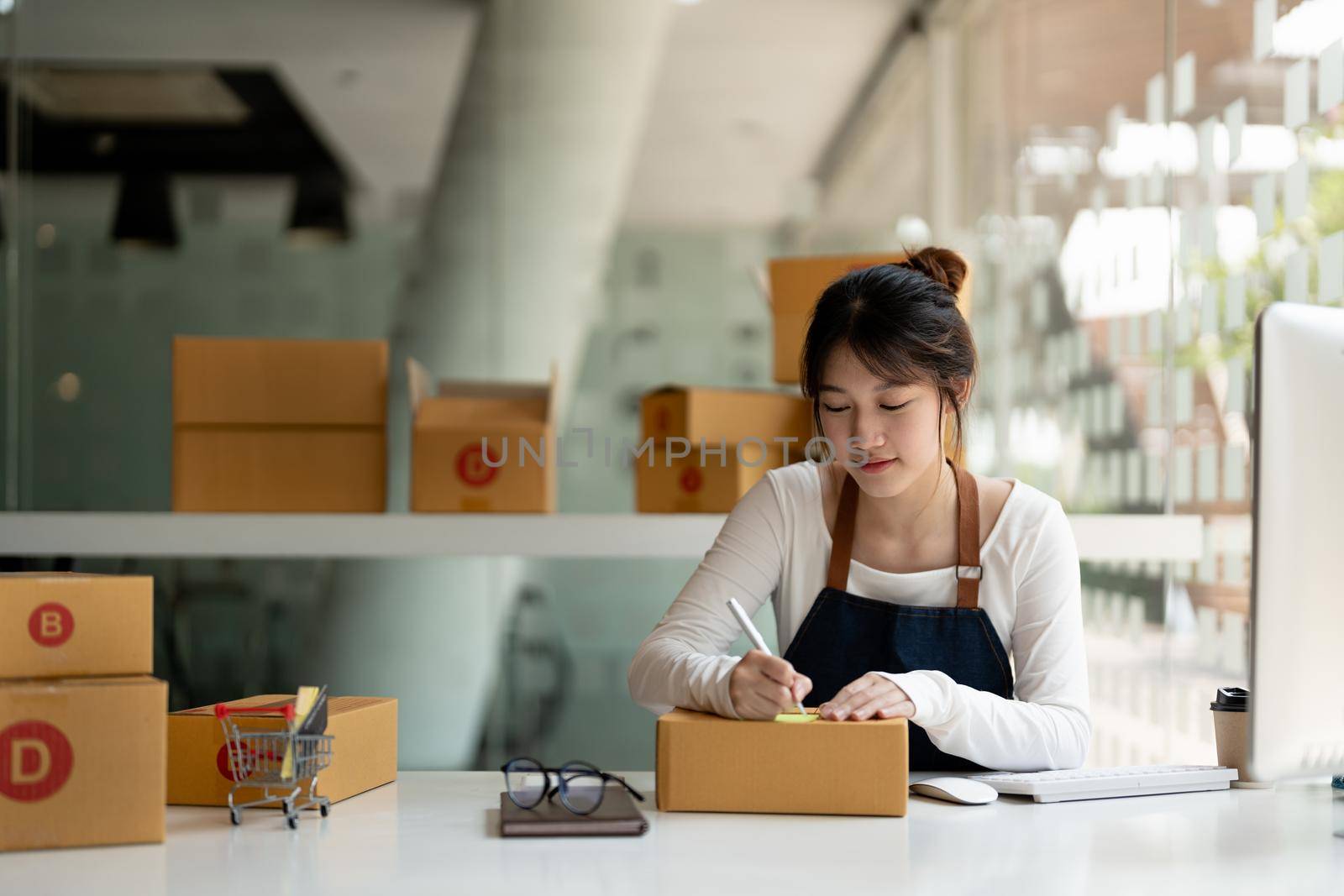 Startup SME small business entrepreneur of freelance asian woman using a laptop with box