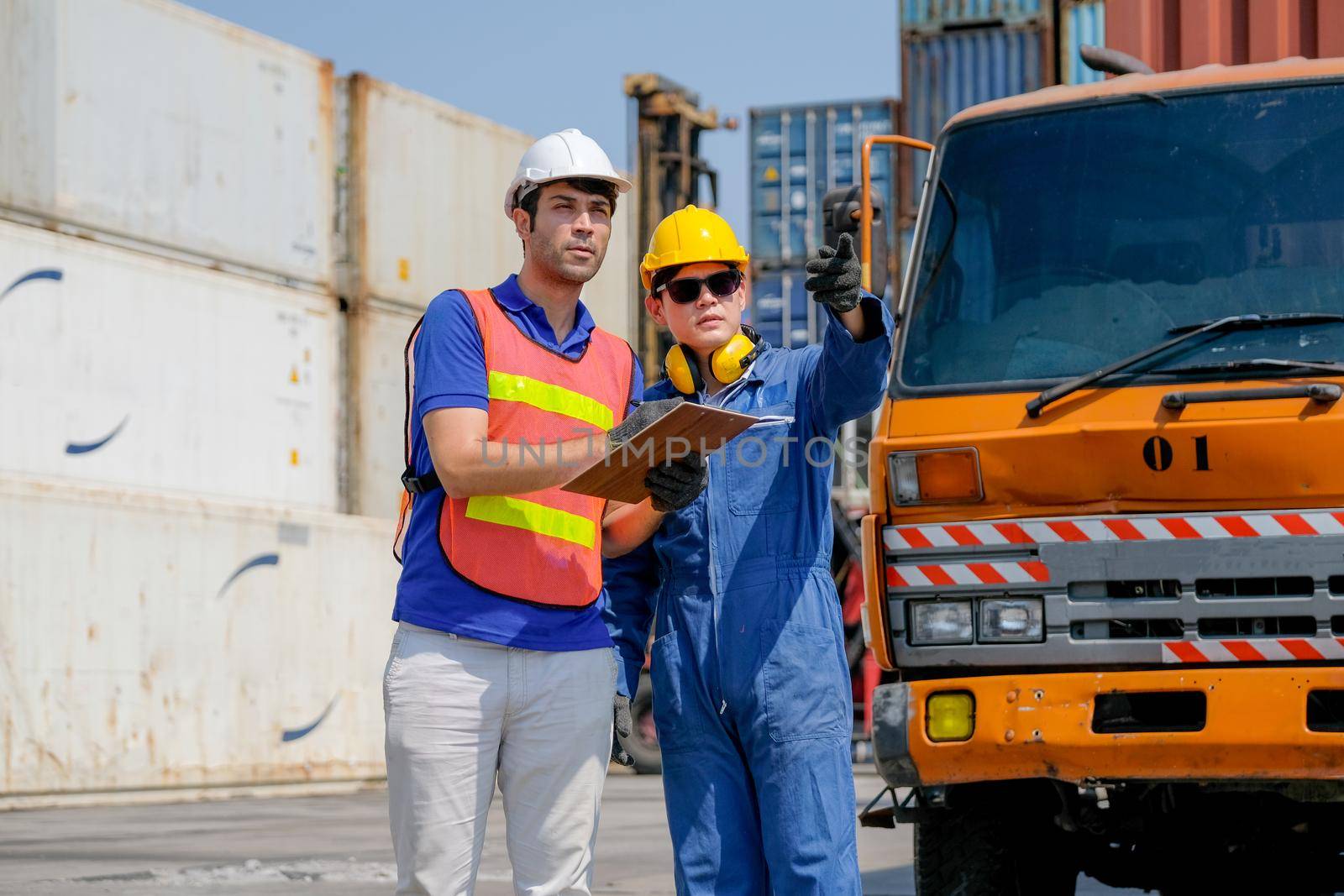 Technician and engineer work together for checking quality and product in cargo container shipping area.