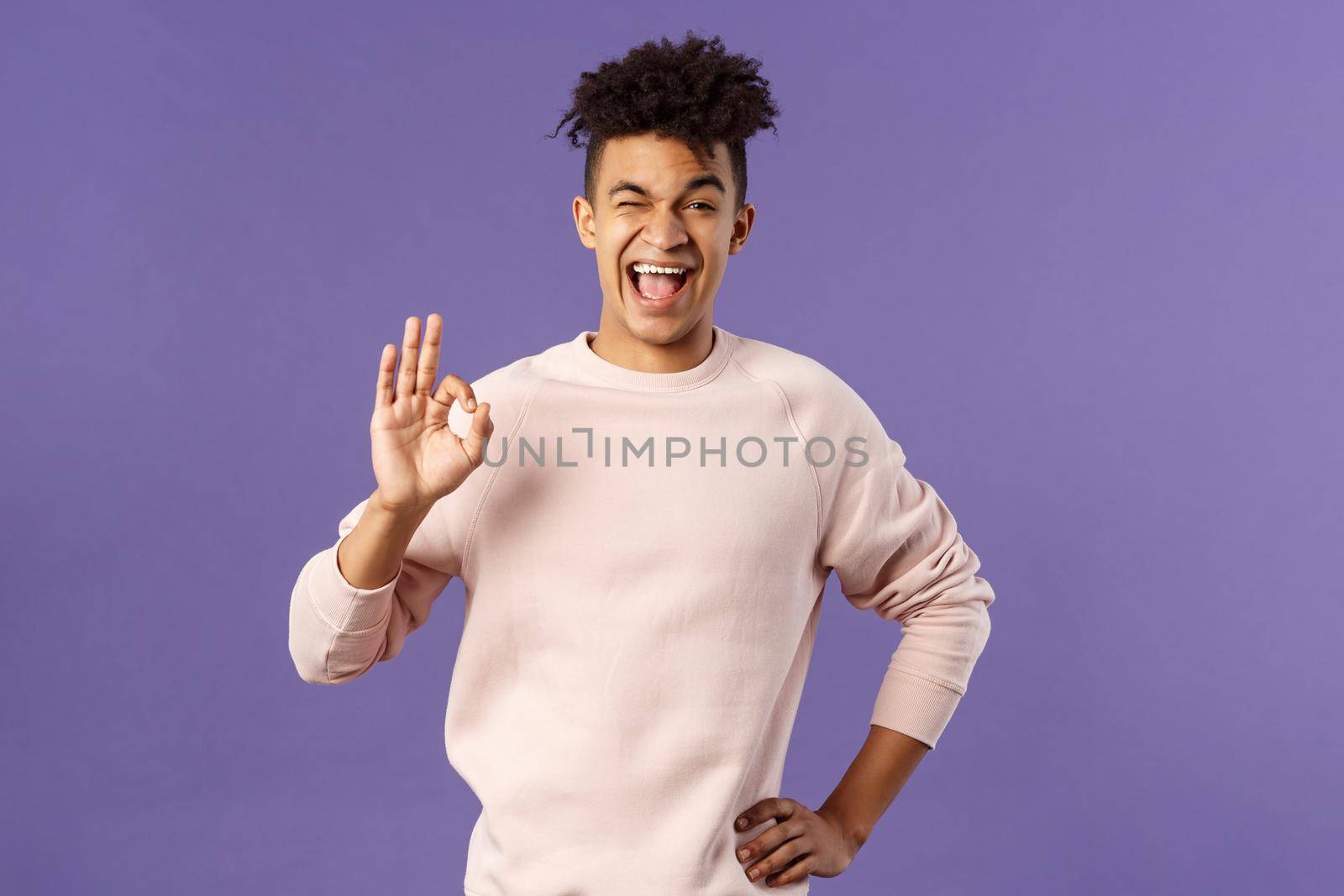 Portrait of enthusiastic young relaxed man show no problem, guarantee gesture, recommend awesome courses where you easily learn new languages, smiling and show ok to assure you.