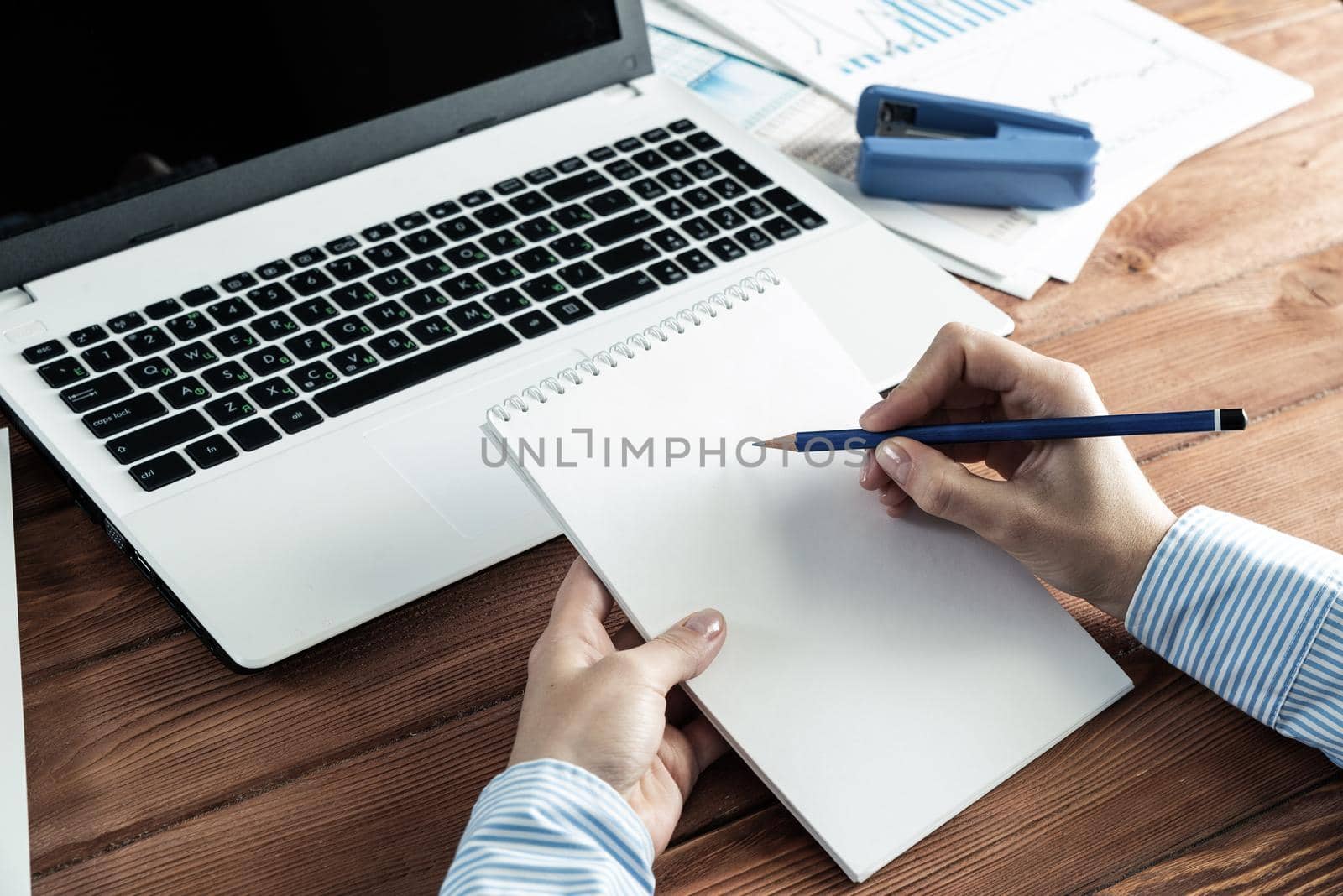 close-up, female hands with notebook and pencil. Business woman working at the table in the office