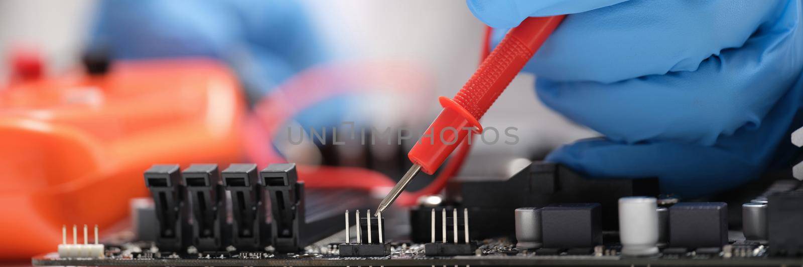 Master repairer testing motherboard with feeler gauge closeup by kuprevich