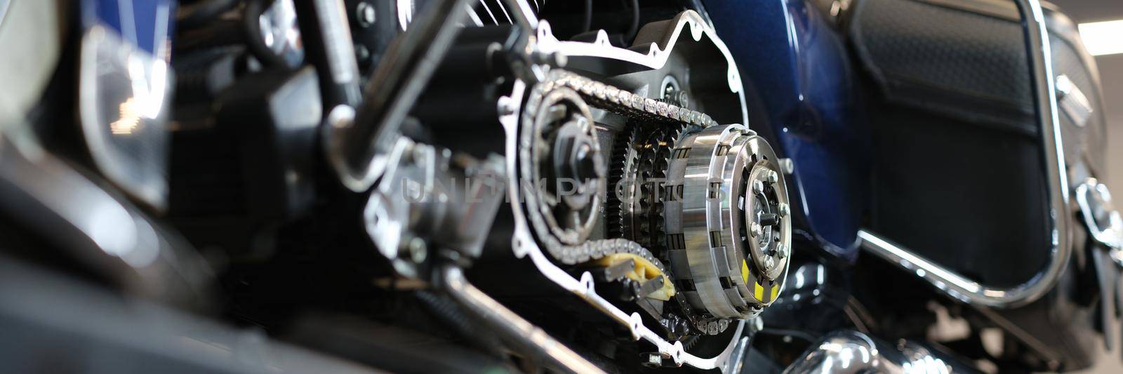 Open chromed motorcycle motor with chain on bench in garage. Engine diagnostics concept