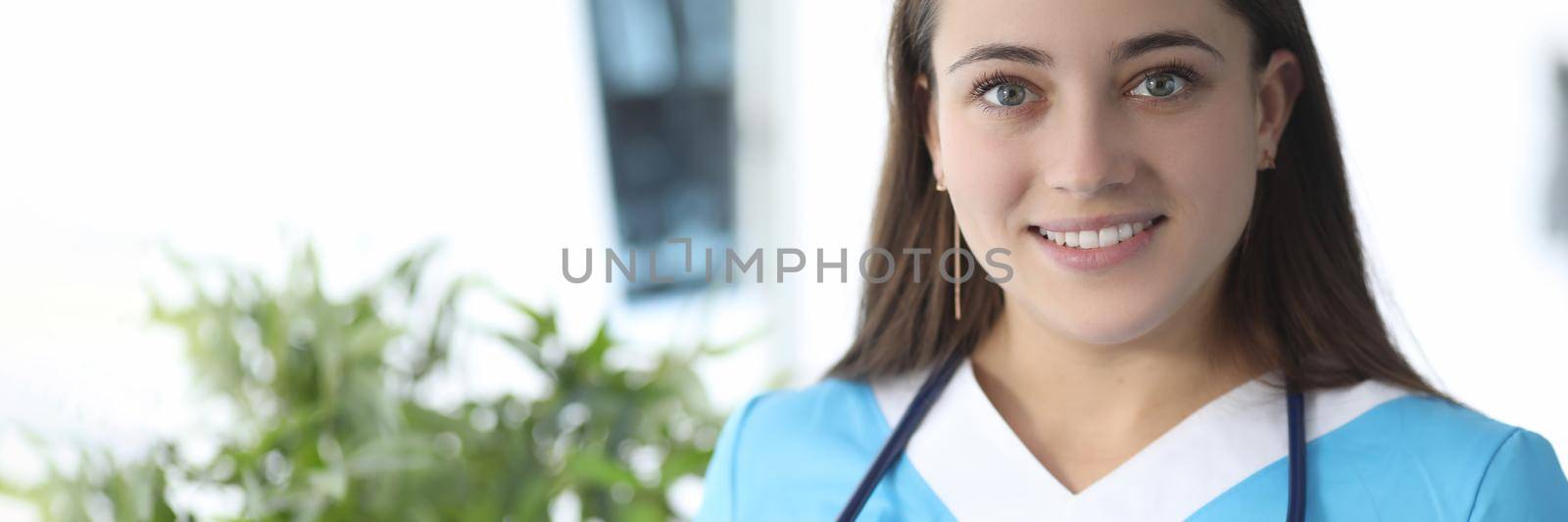 Portrait of smiling female doctor with stethoscope in medical clinic. Quality medical services concept