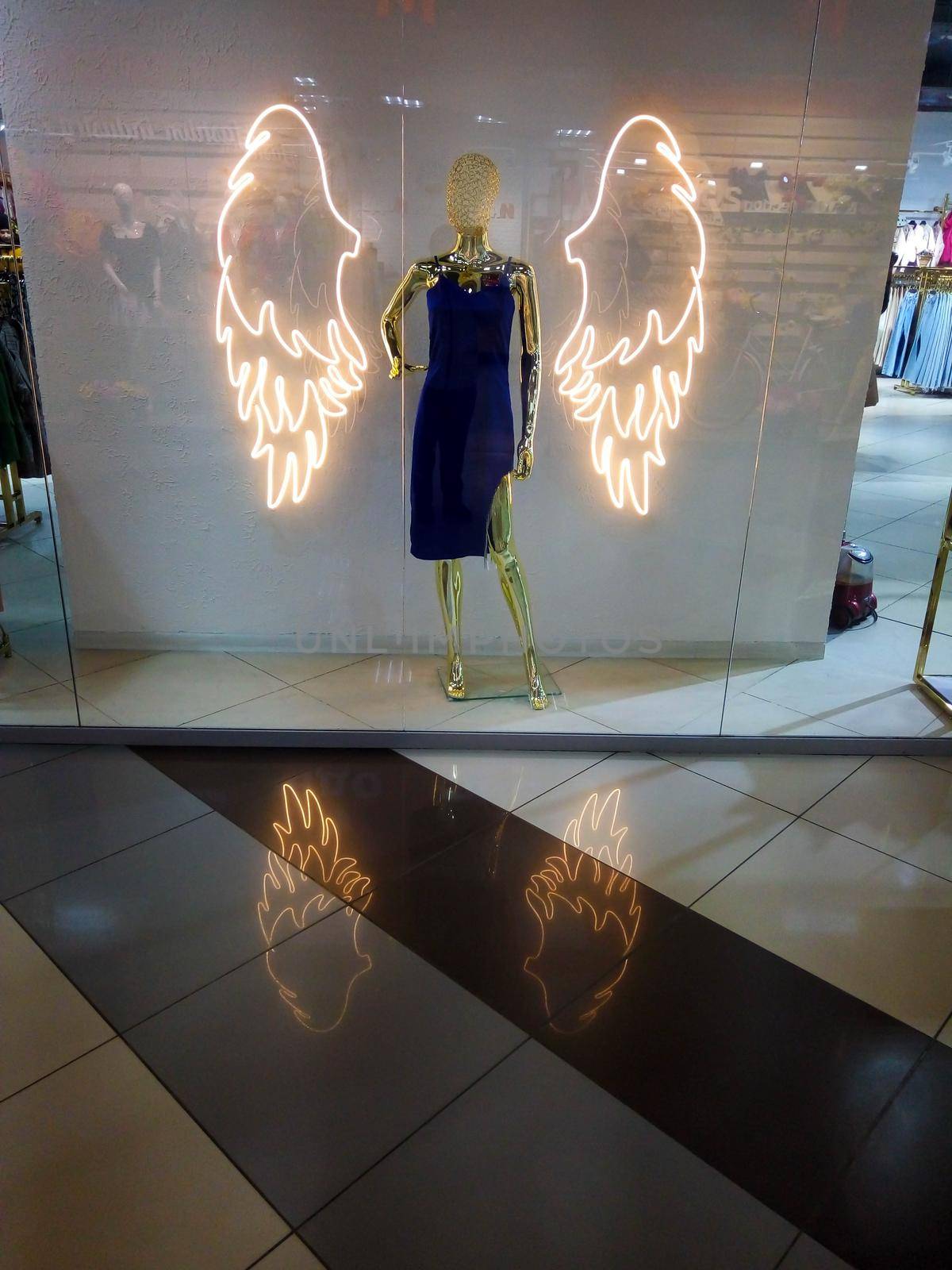 Shop window with angel mannequin, beautiful shopping center design.