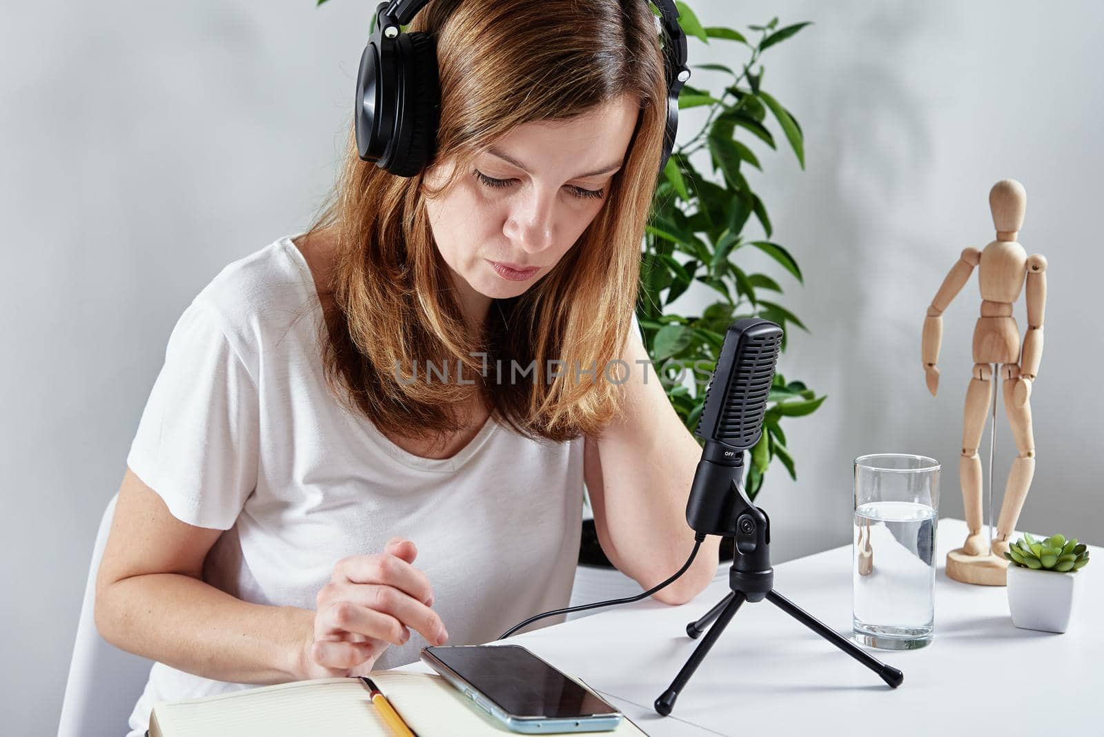 Woman listening online course in headphones, distance education. Freelancer sitting at workplace and procrastinating. Lazy and distracted employee