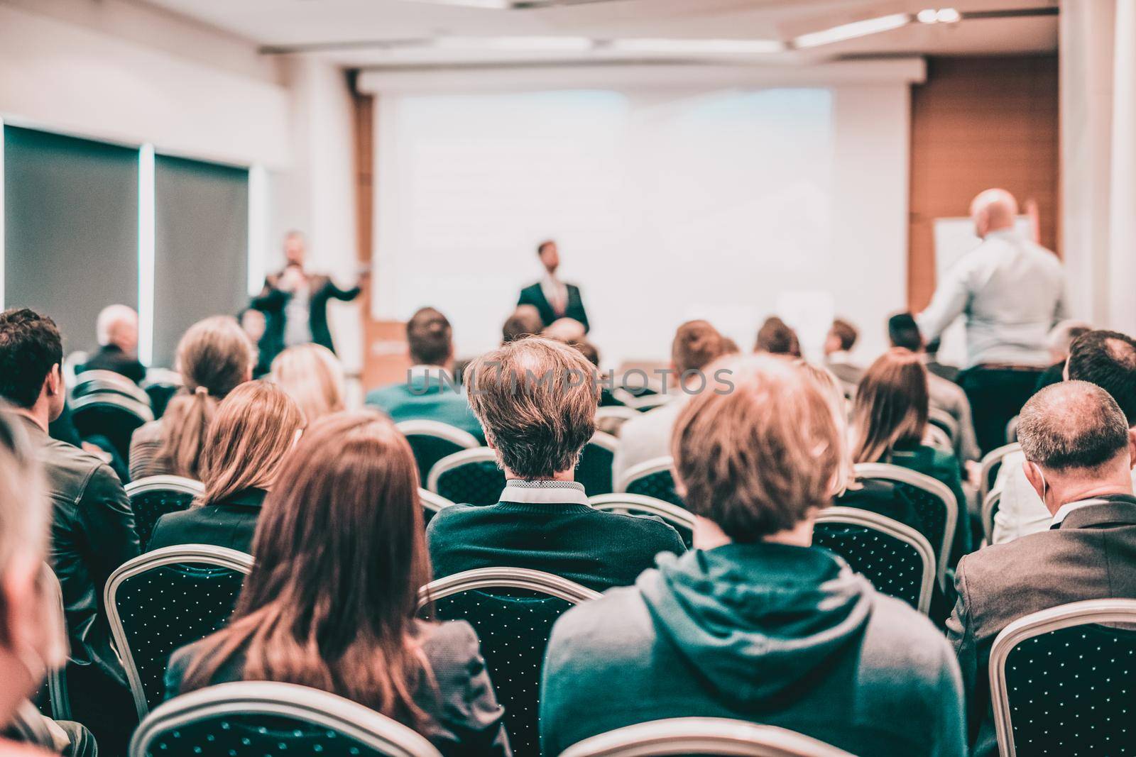 I have a question. Group of business people sitting in conference hall. Businessman raising his arm. Conference and Presentation. Business and Entrepreneurship by kasto