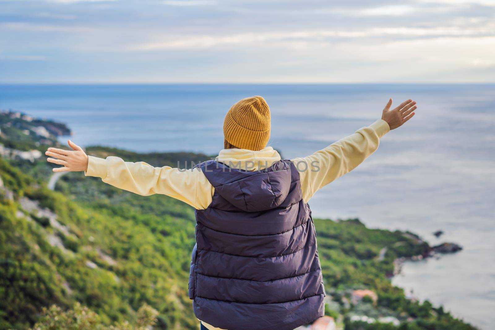 Woman in the mountains of Montenegro in warm clothes. Travel to Montenegro in spring, autumn, winter.