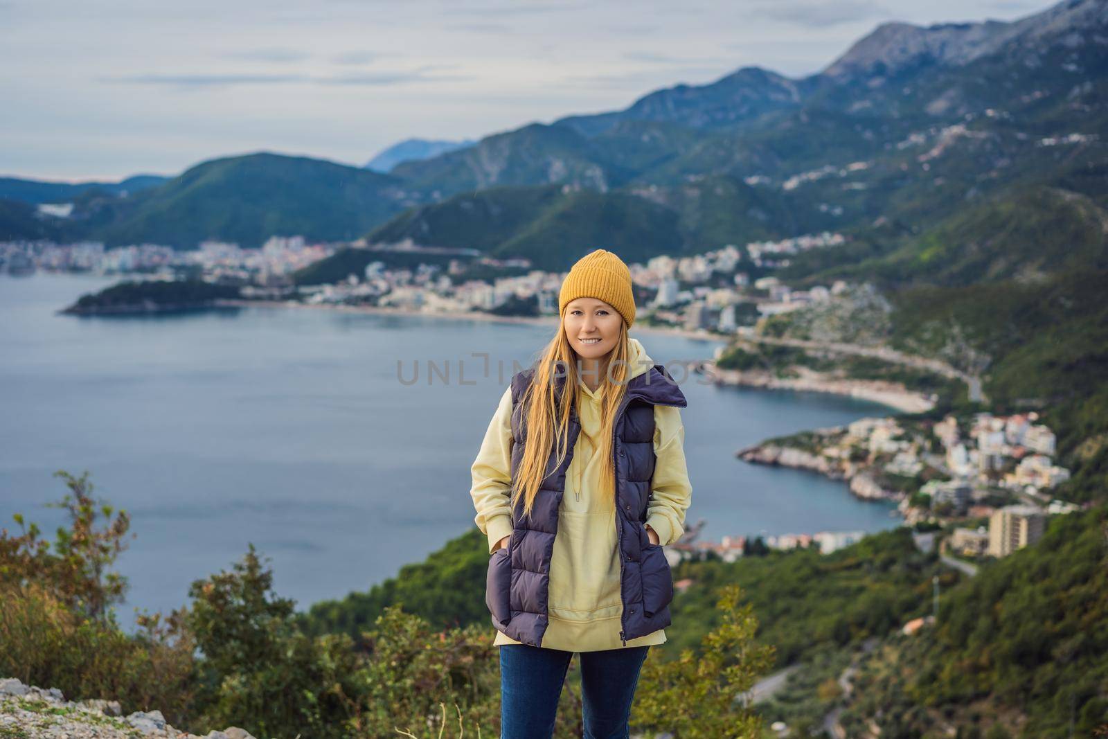 Woman in the mountains of Montenegro in warm clothes. Travel to Montenegro in spring, autumn, winter.