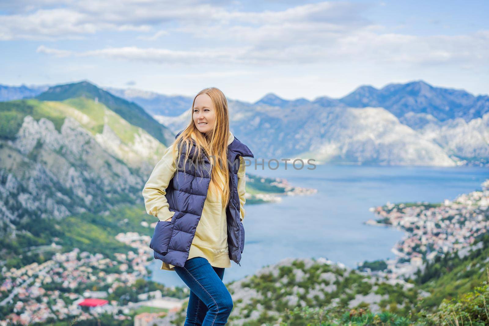 Woman tourist enjoys the view of Kotor. Montenegro. Bay of Kotor, Gulf of Kotor, Boka Kotorska and walled old city. Travel to Montenegro concept. Fortifications of Kotor is on UNESCO World Heritage List since 1979 by galitskaya