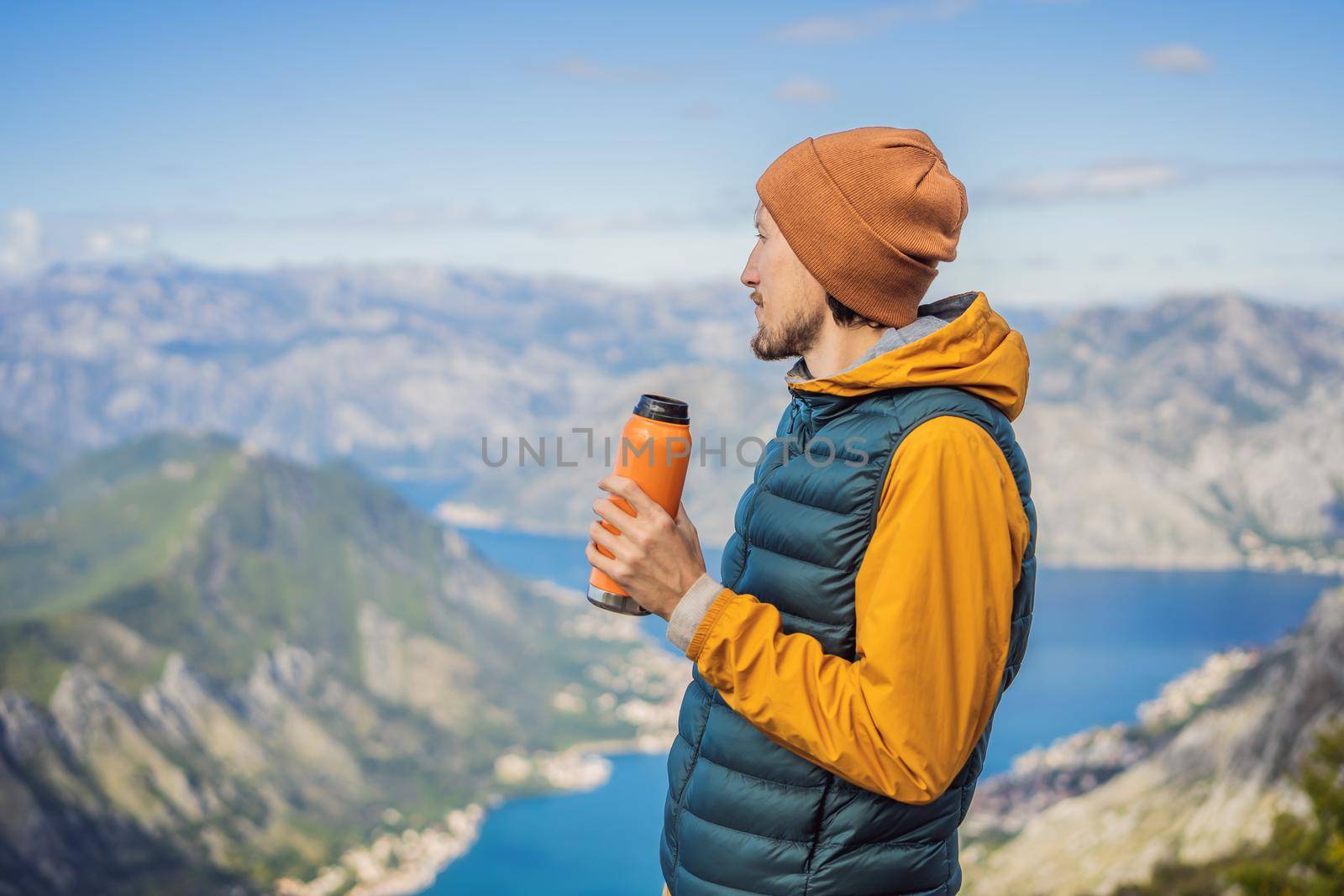 Man tourist enjoys the view of Kotor. Montenegro. Bay of Kotor, Gulf of Kotor, Boka Kotorska and walled old city. Travel to Montenegro concept. Fortifications of Kotor is on UNESCO World Heritage List since 1979 by galitskaya