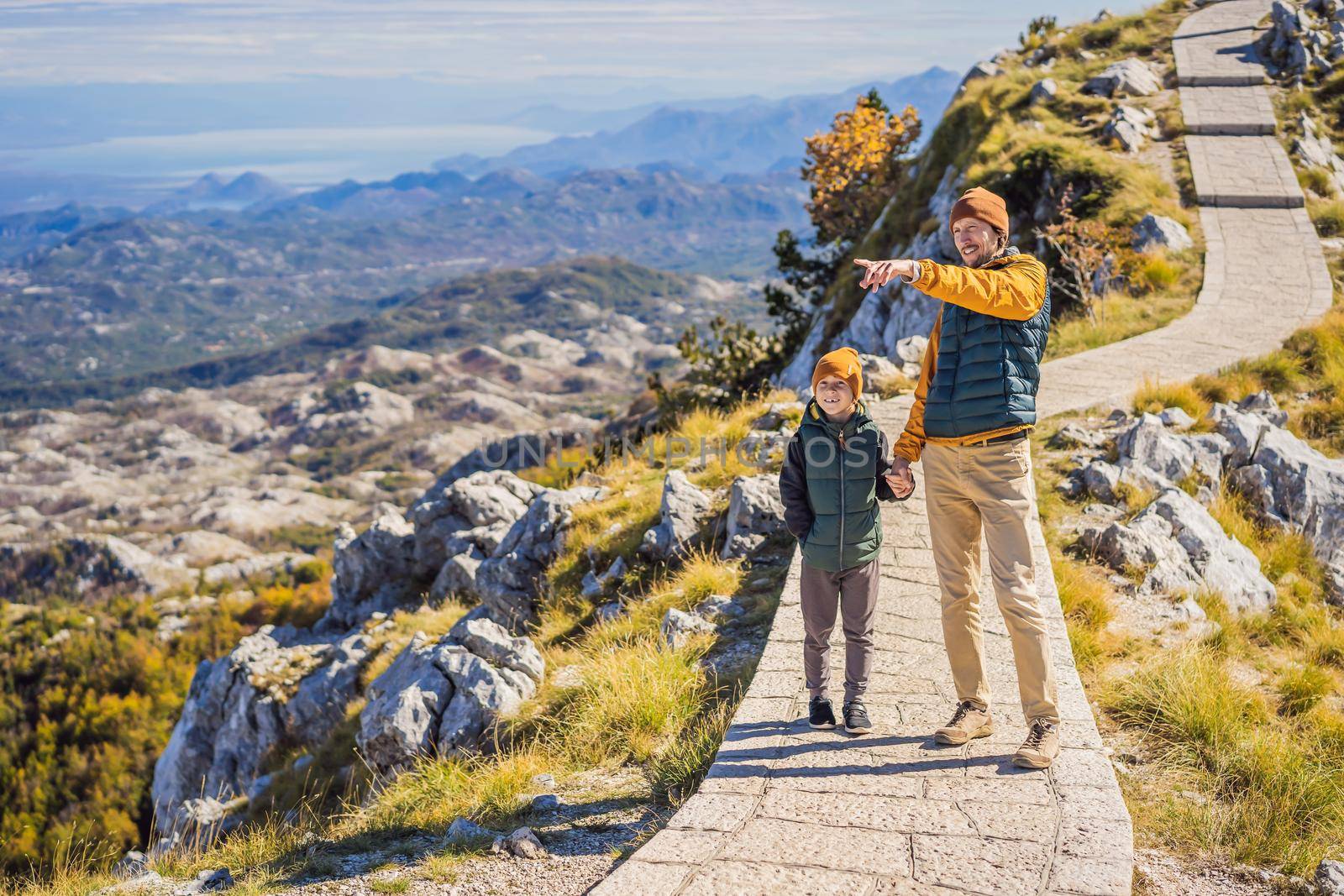 Dad and son travellers in mountain landscape at national park Lovcen, Montenegro. Travel to Montenegro with children concept by galitskaya