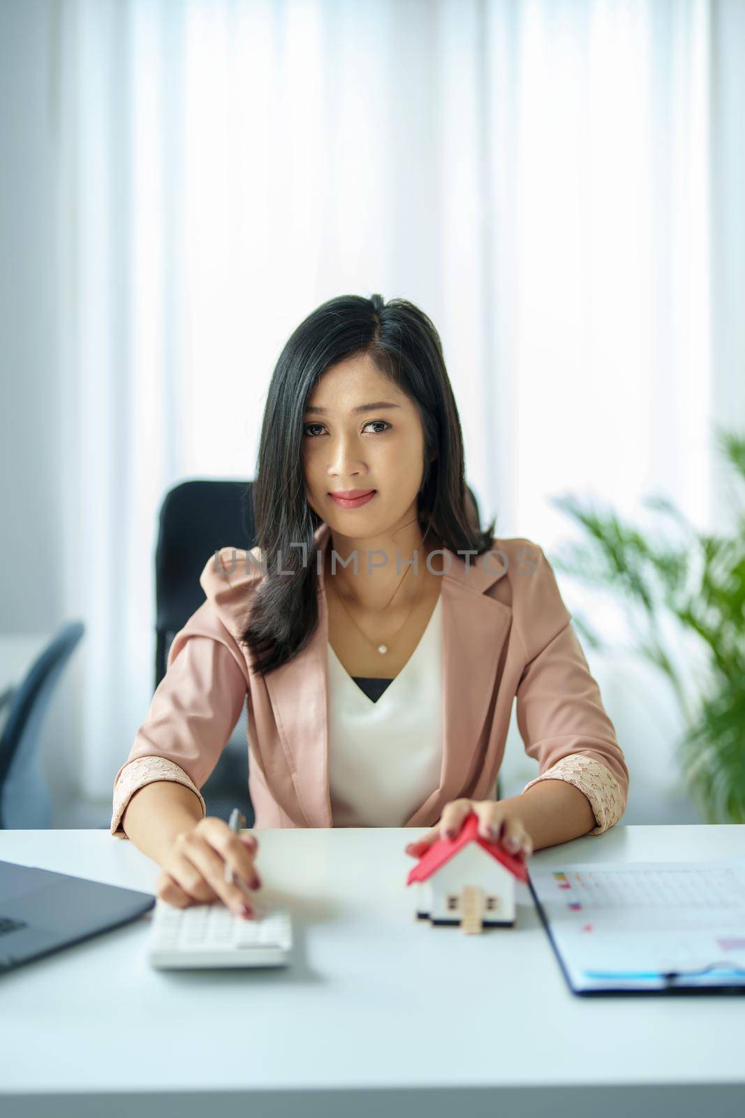 Entrepreneurs, business owners, accountants, real estate agents, Portrait of asian woman uses a calculator to calculate her home budget to assess the risks of investing in real estate