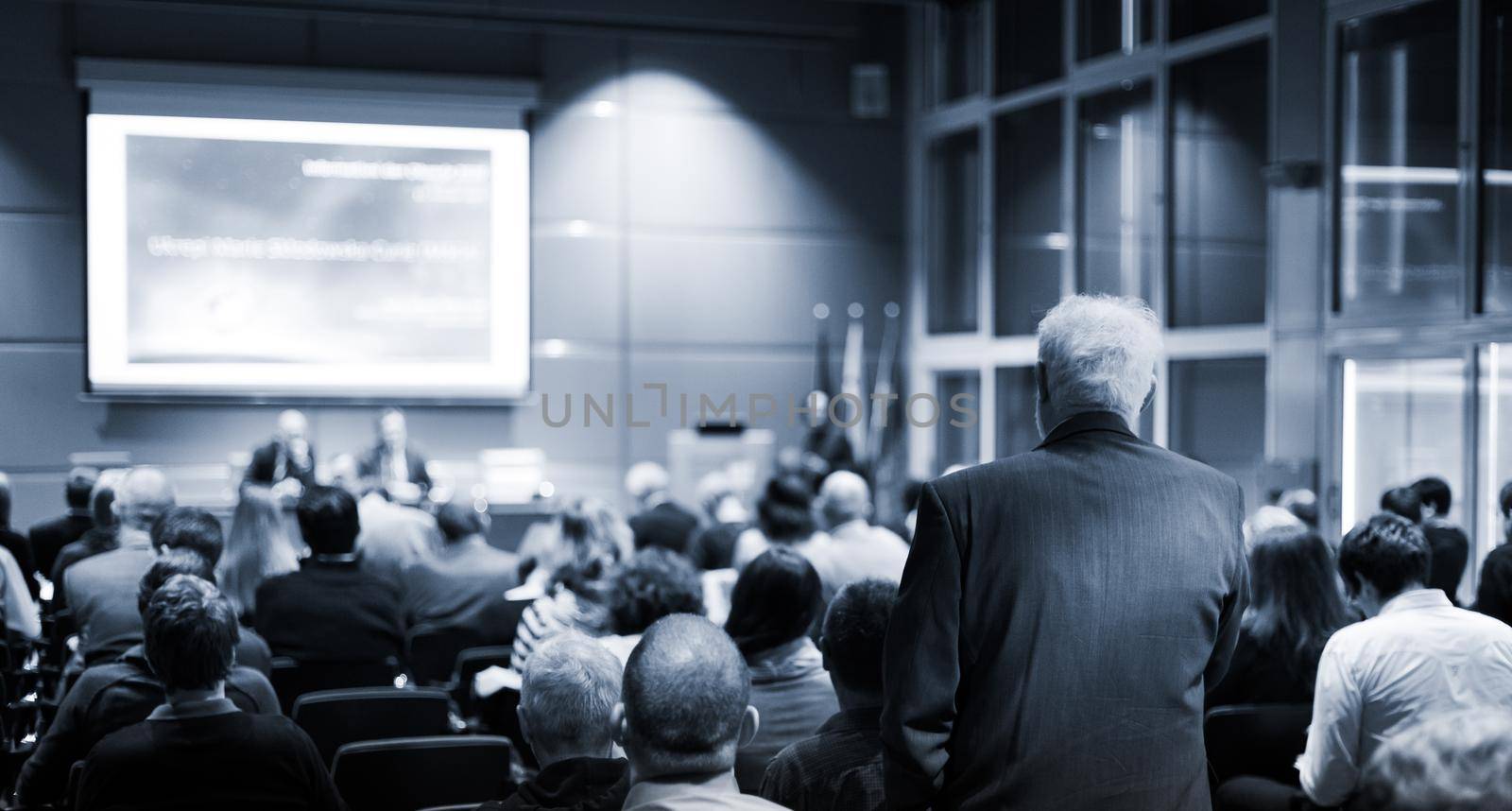 I have a question. Group of business people sitting in conference hall. Businessman raising his arm. Conference and Presentation. Business and Entrepreneurship by kasto