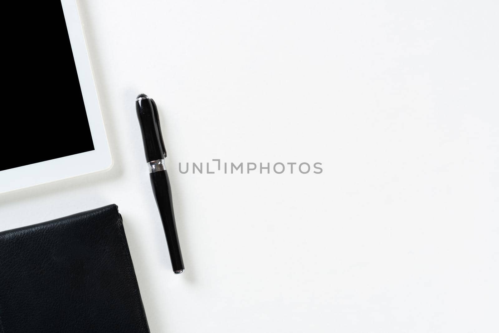 Still life of modern office workspace with supplies. Flat lay white desk with black leather wallet and tablet computer. Online shopping and payment. Creativity and innovation concept with copy space