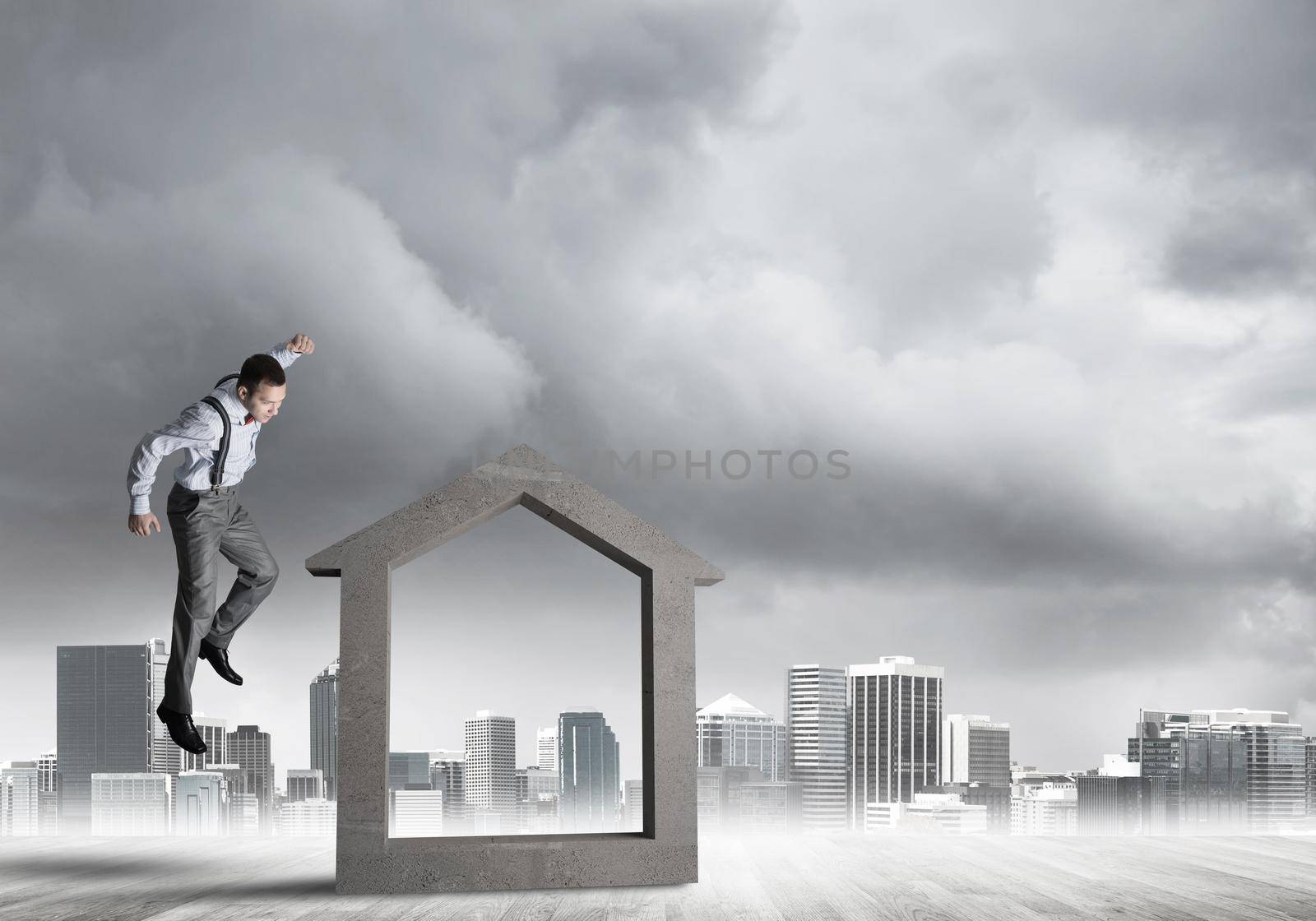 Determined businessman going to break with fist house concrete figure