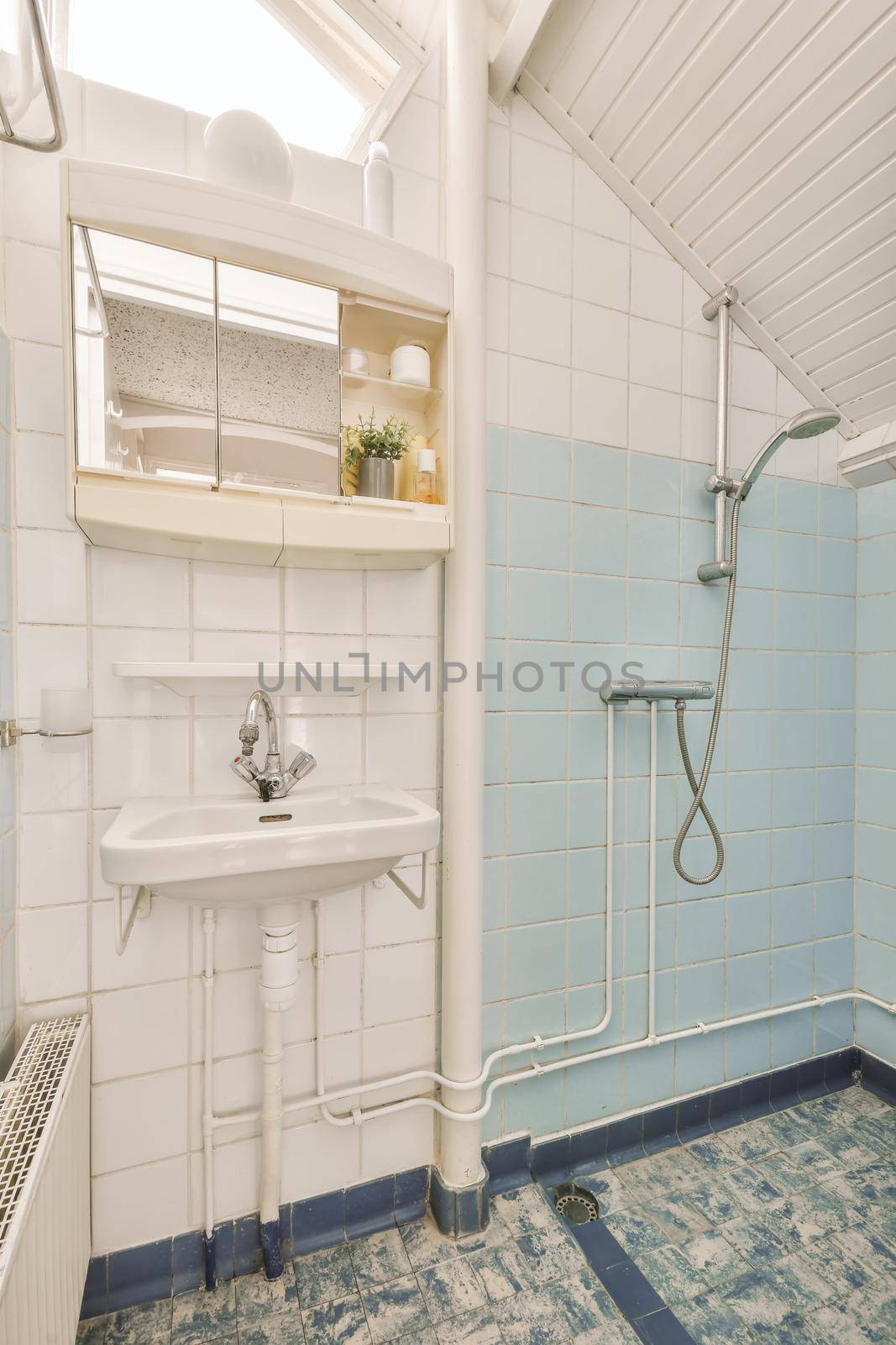 Bathroom decorated with multicolored tiles with sink and shower stall in a modern house