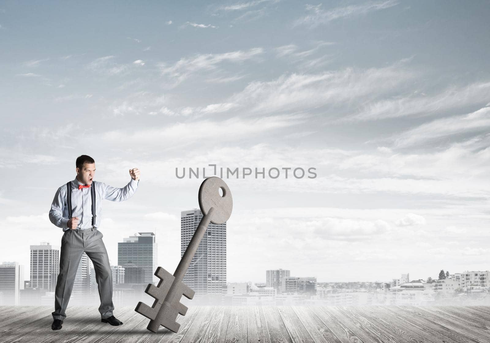 Determined businessman against modern cityscape breaking with fist stone key figure
