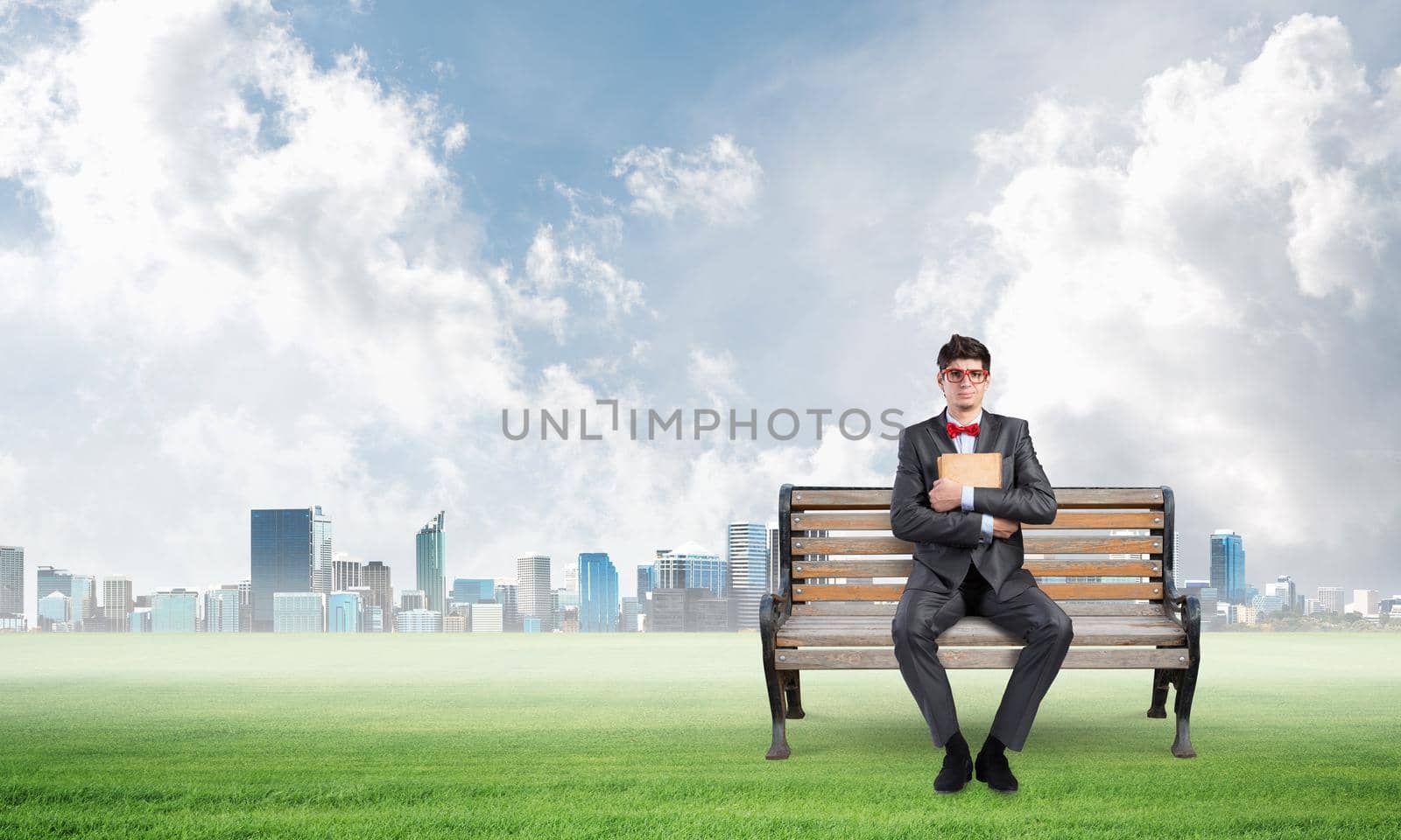 Young student sits on a wooden bench with a book