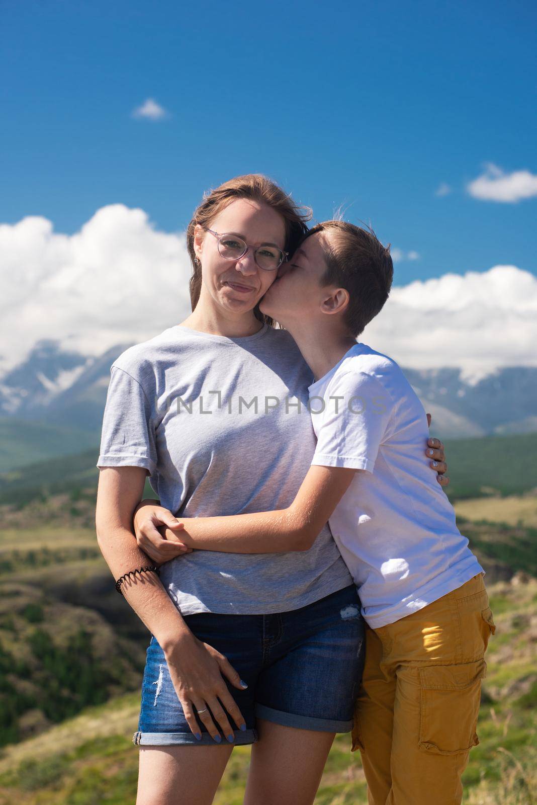 A child embraces mom in the mountain trip. Domestic tourism, travel, lesure and freedom. Altai mountain, beauty summer evening landcape