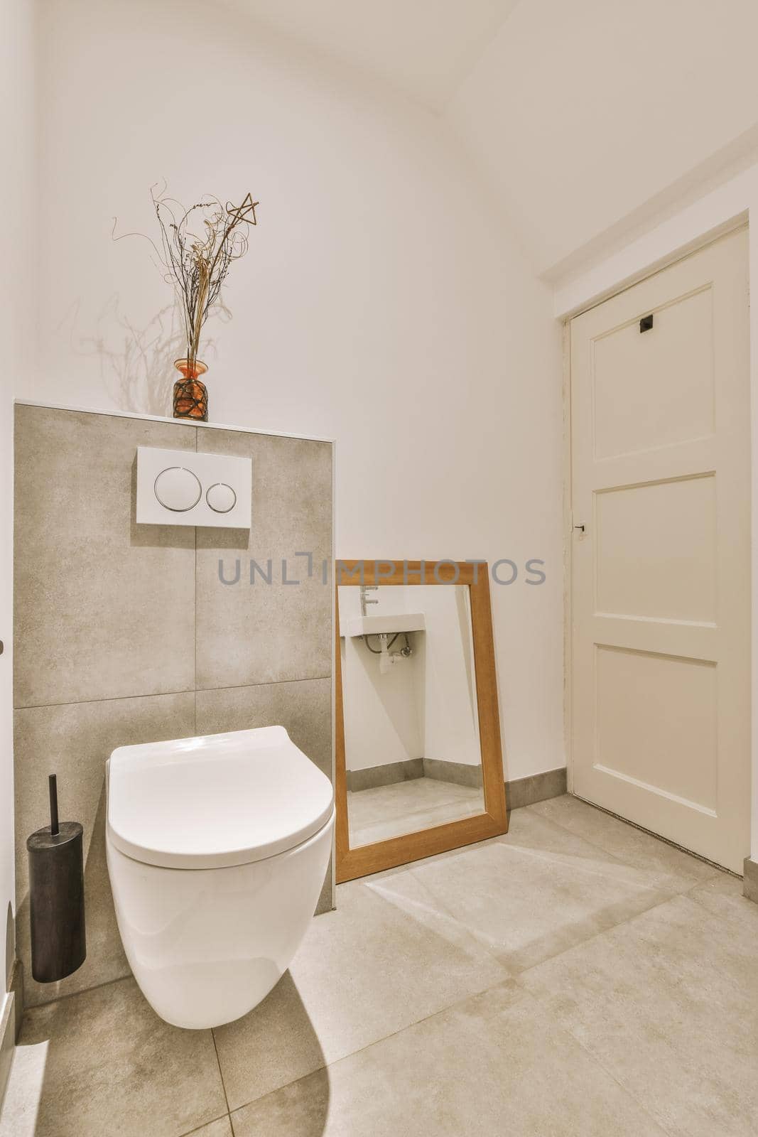 Marble bathroom with ceramic toilet and square mirror in a cozy house
