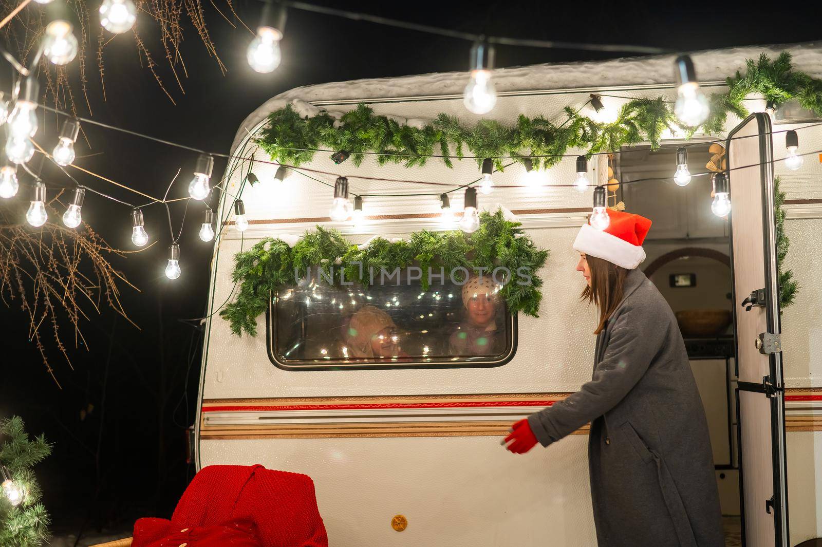 Caucasian woman and two with sons celebrate Christmas in a camper. Mom of two boys dress up the van. by mrwed54
