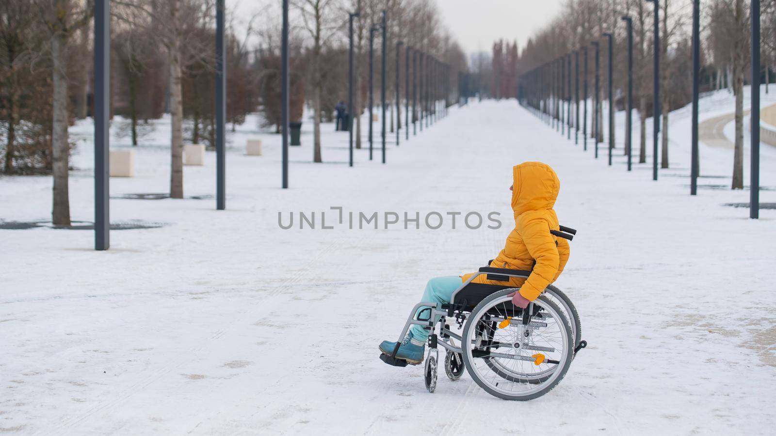 Disabled woman in a wheelchair outdoors in winter. by mrwed54