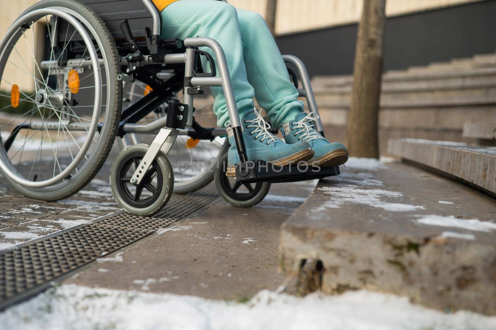 Woman in a wheelchair near the stairs in the park in winter. by mrwed54