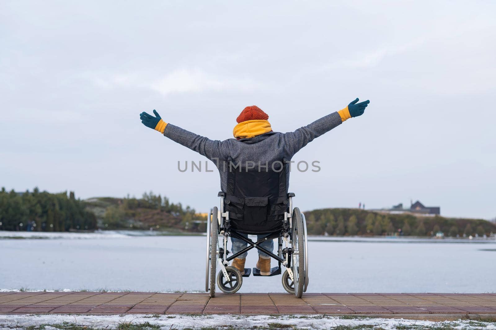 Caucasian woman in a wheelchair walks by the lake in winter. by mrwed54